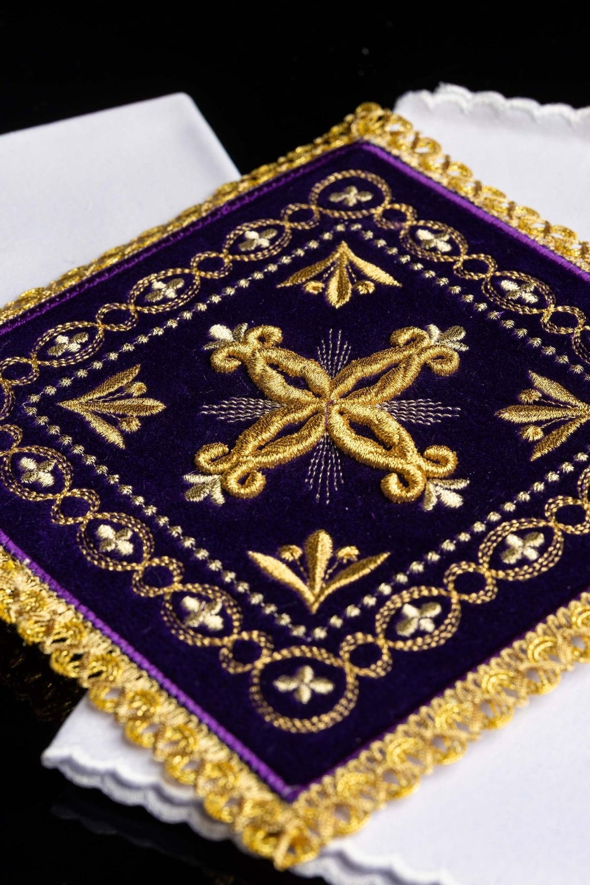 Purple velvet chalice pall close-up showing gold cross embroidery, floral motifs and gold trim