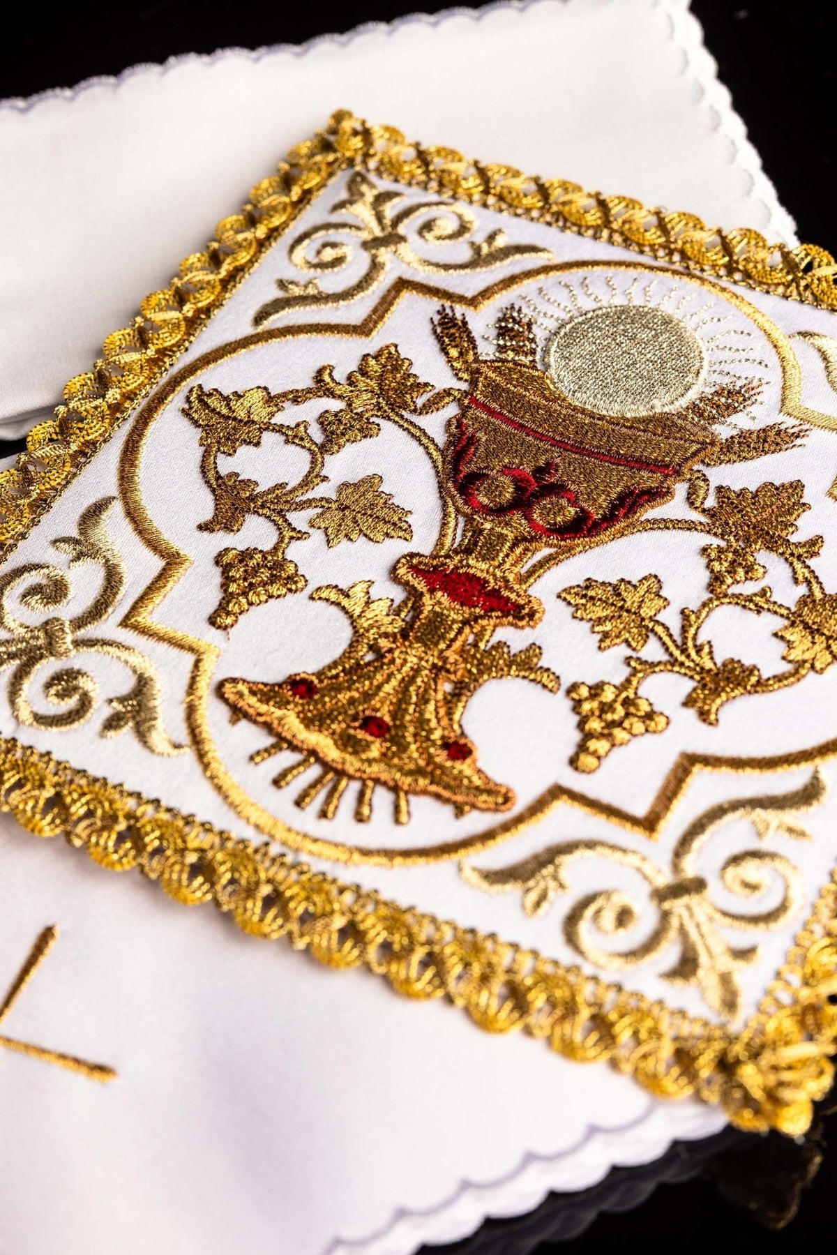Altar linen set close-up showing gold embroidered communion chalice, wheat and vine motifs