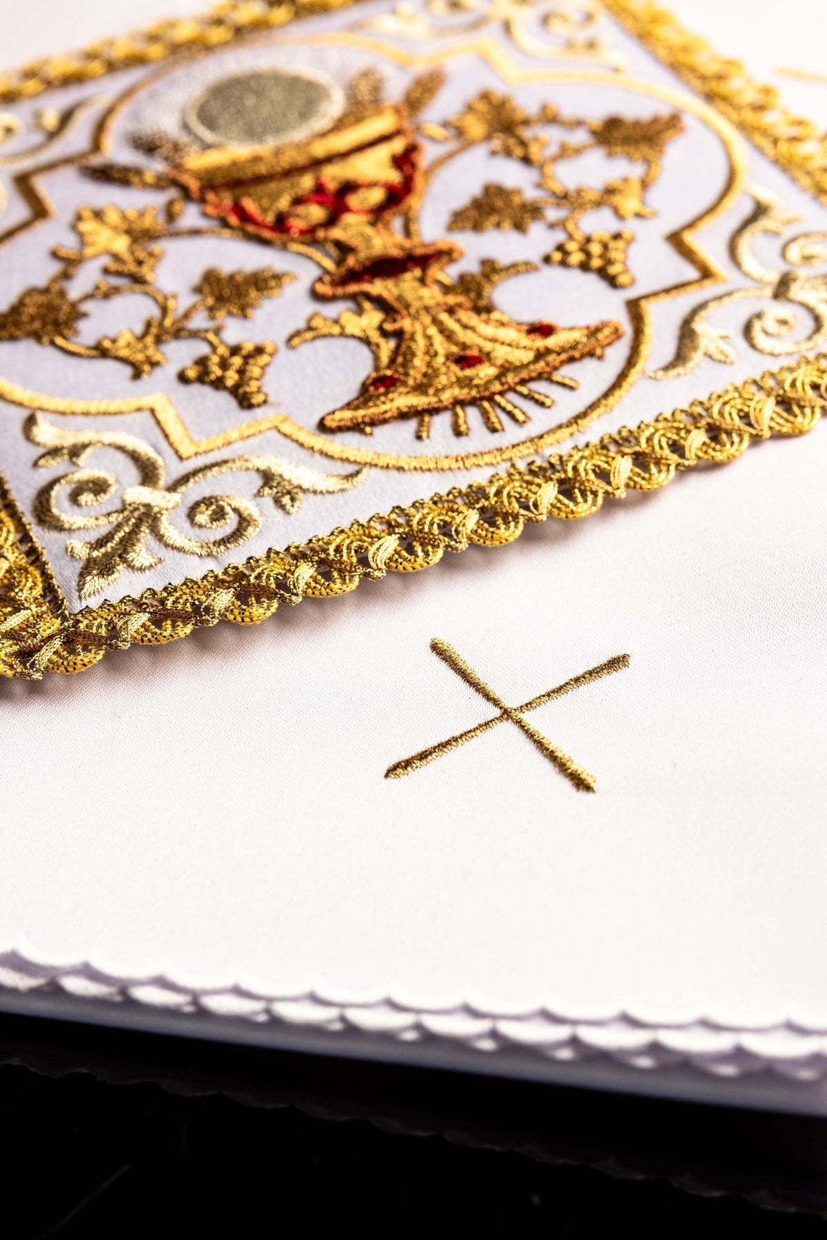 Altar linen set detail with embroidered gold cross and scalloped white edge