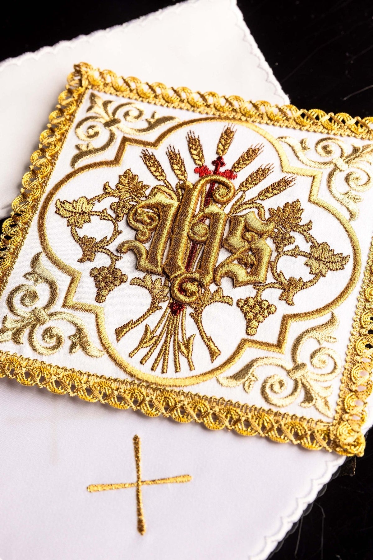 Altar linen set close-up showing embroidered gold IHS symbol, wheat and vine motifs