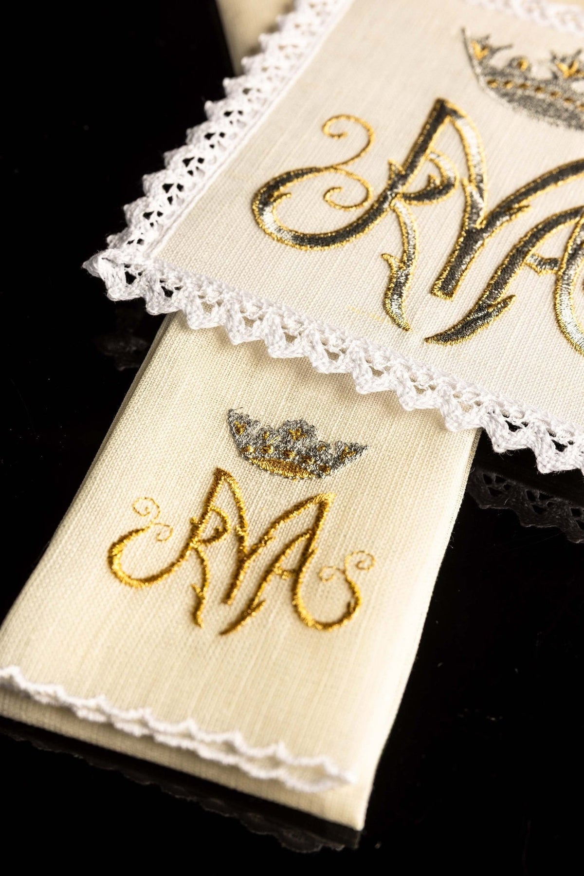 Altar linen set detail showing embroidered Marian symbol and white lace edging