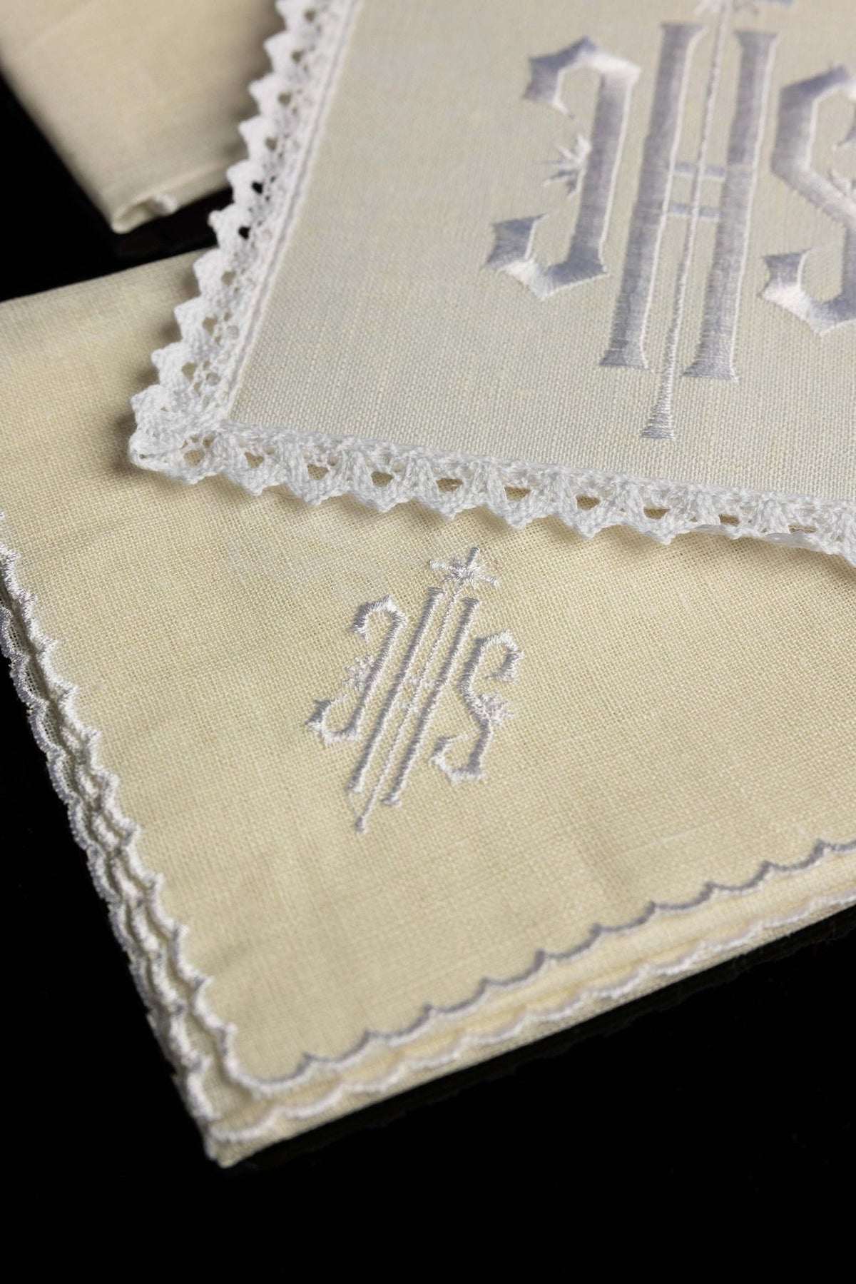 Altar linen set close-up showing white embroidered IHS motif and scalloped edging