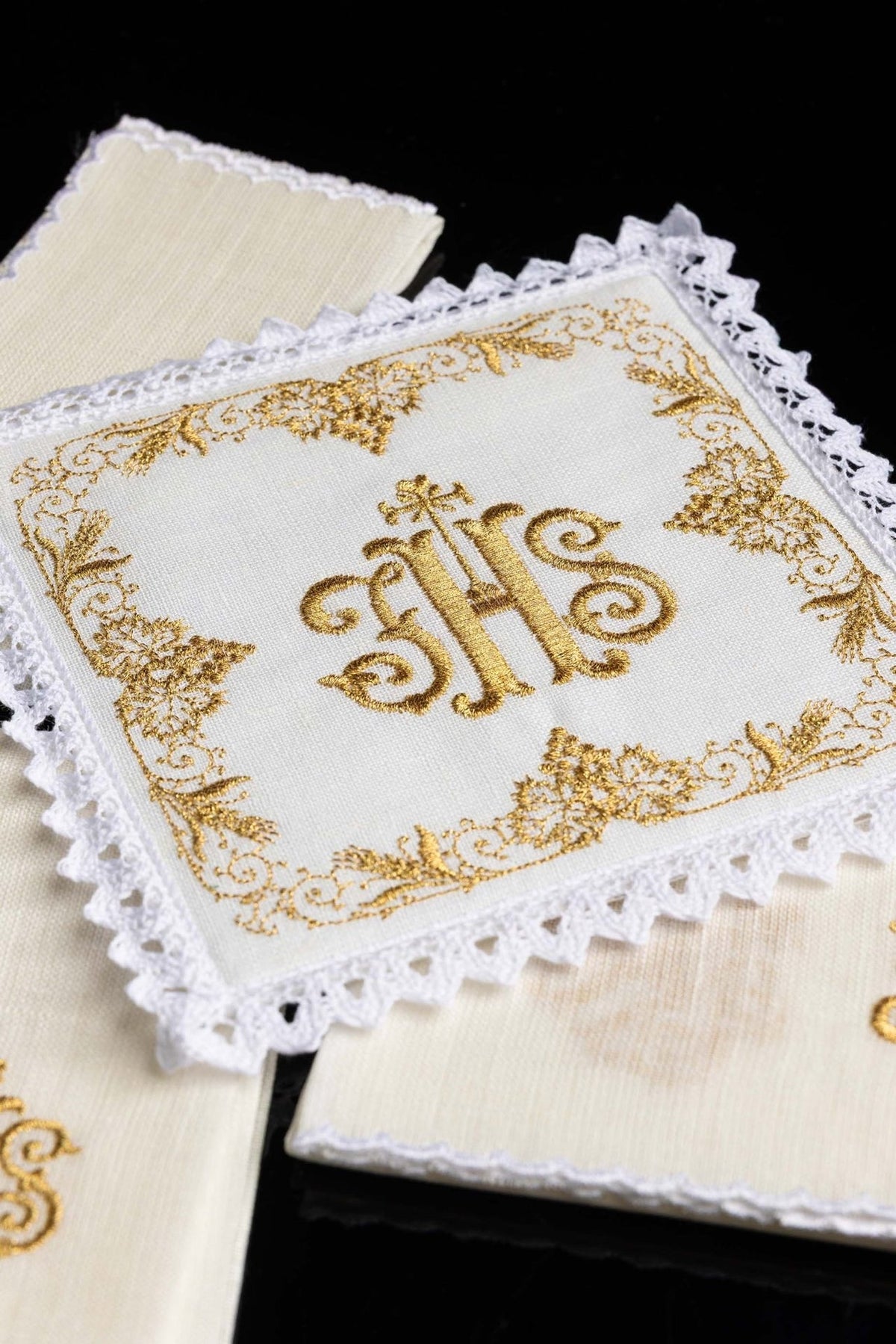 Altar linen set close-up showing gold IHS embroidery, floral border and white lace trim