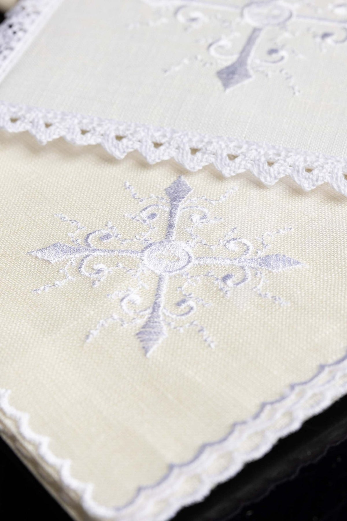Altar linen set detail showing white cross embroidery on ivory fabric