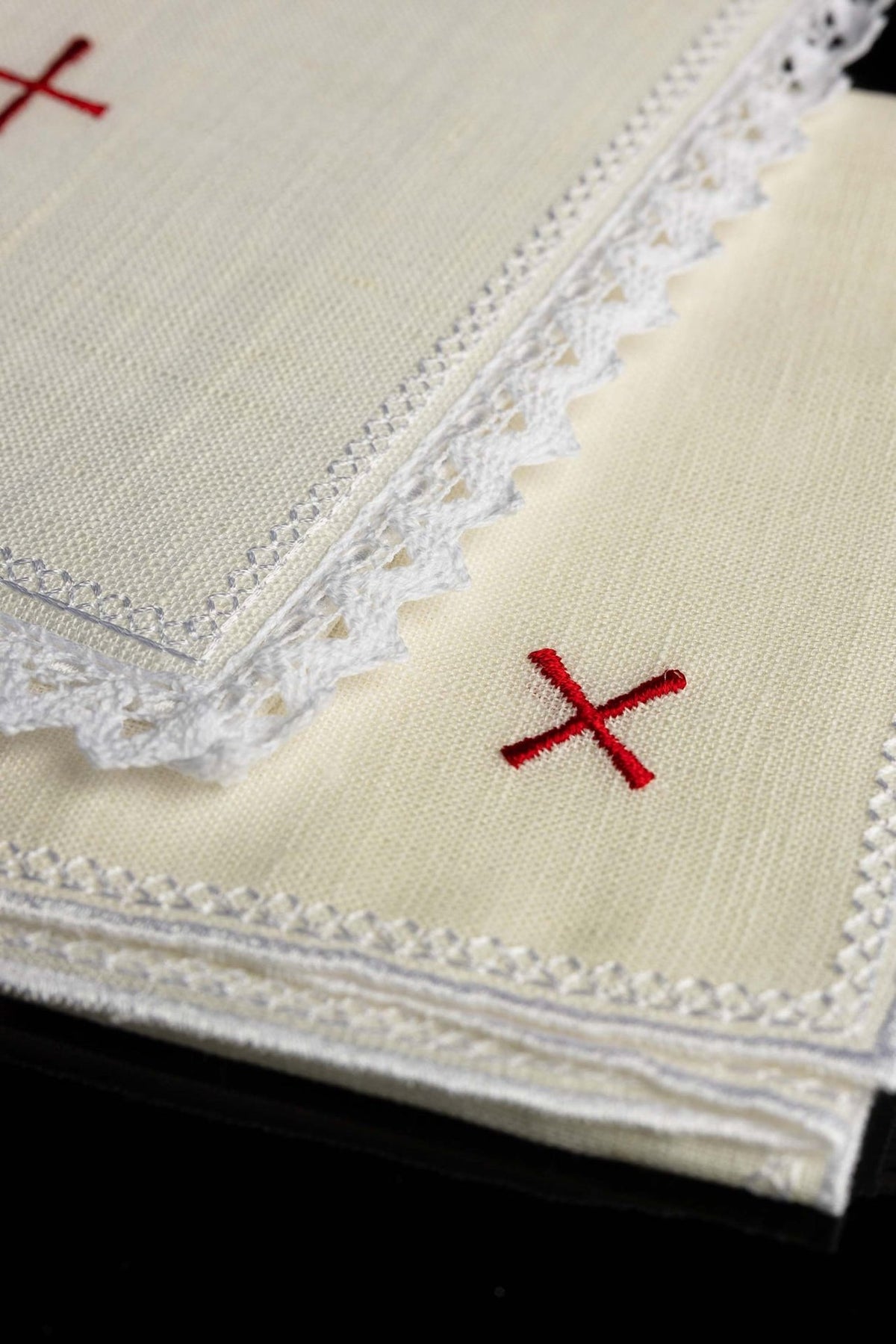 Altar linen set detail showing red cross embroidery and white lace trim
