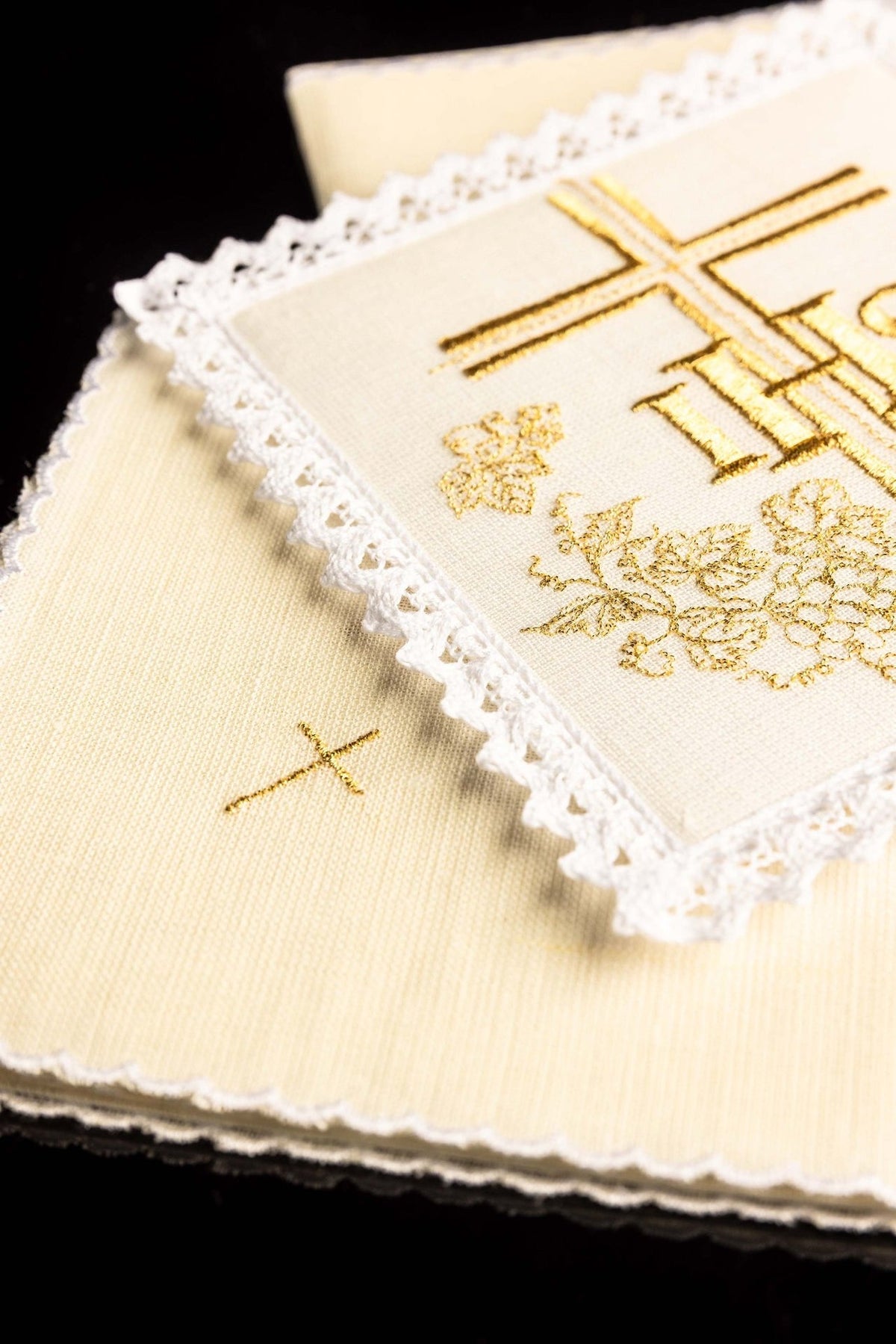 Altar linen set detail showing ivory fabric, lace edging and small gold cross
