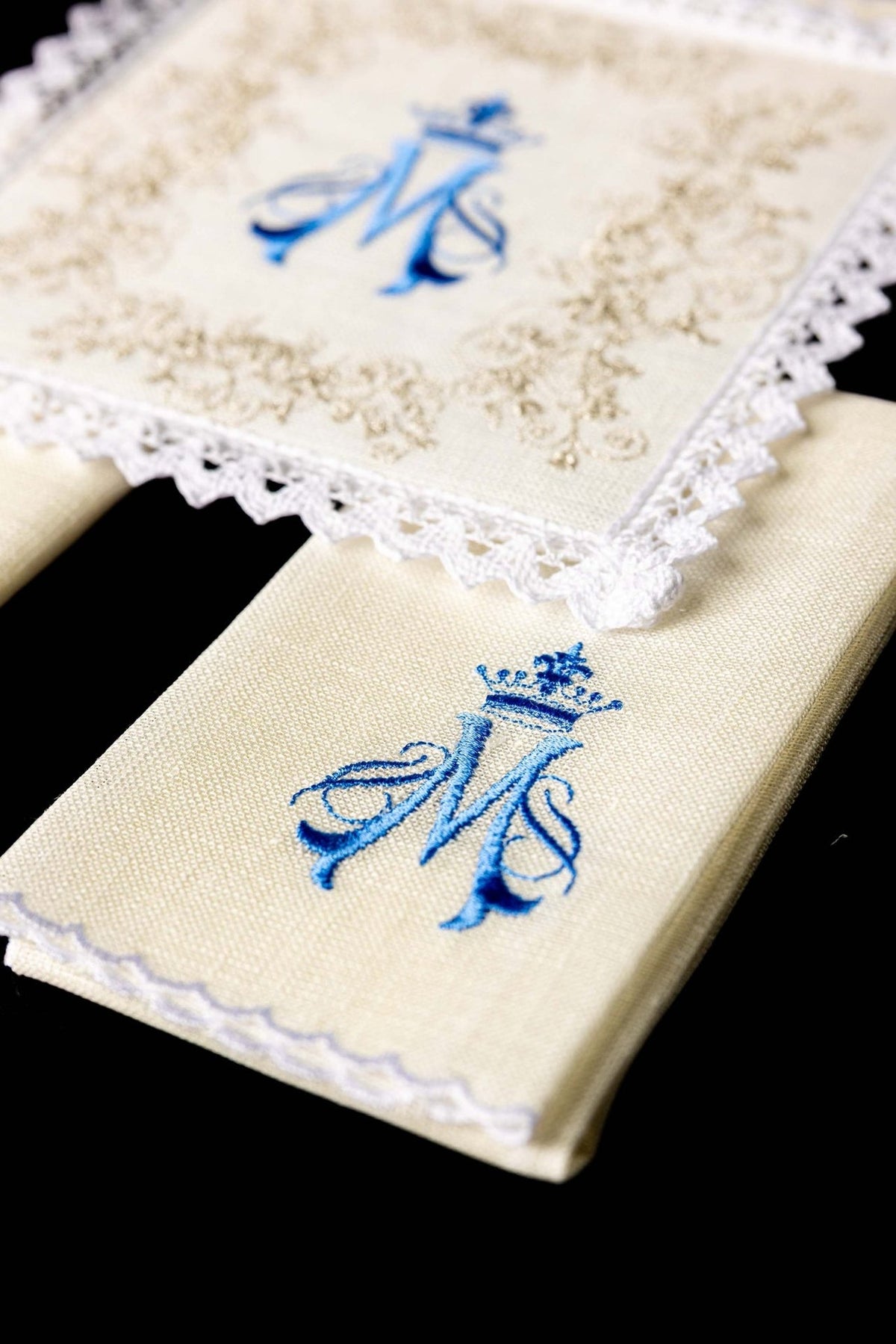 Altar linen set detail showing cream linen fabric, blue Marian symbol and white lace border