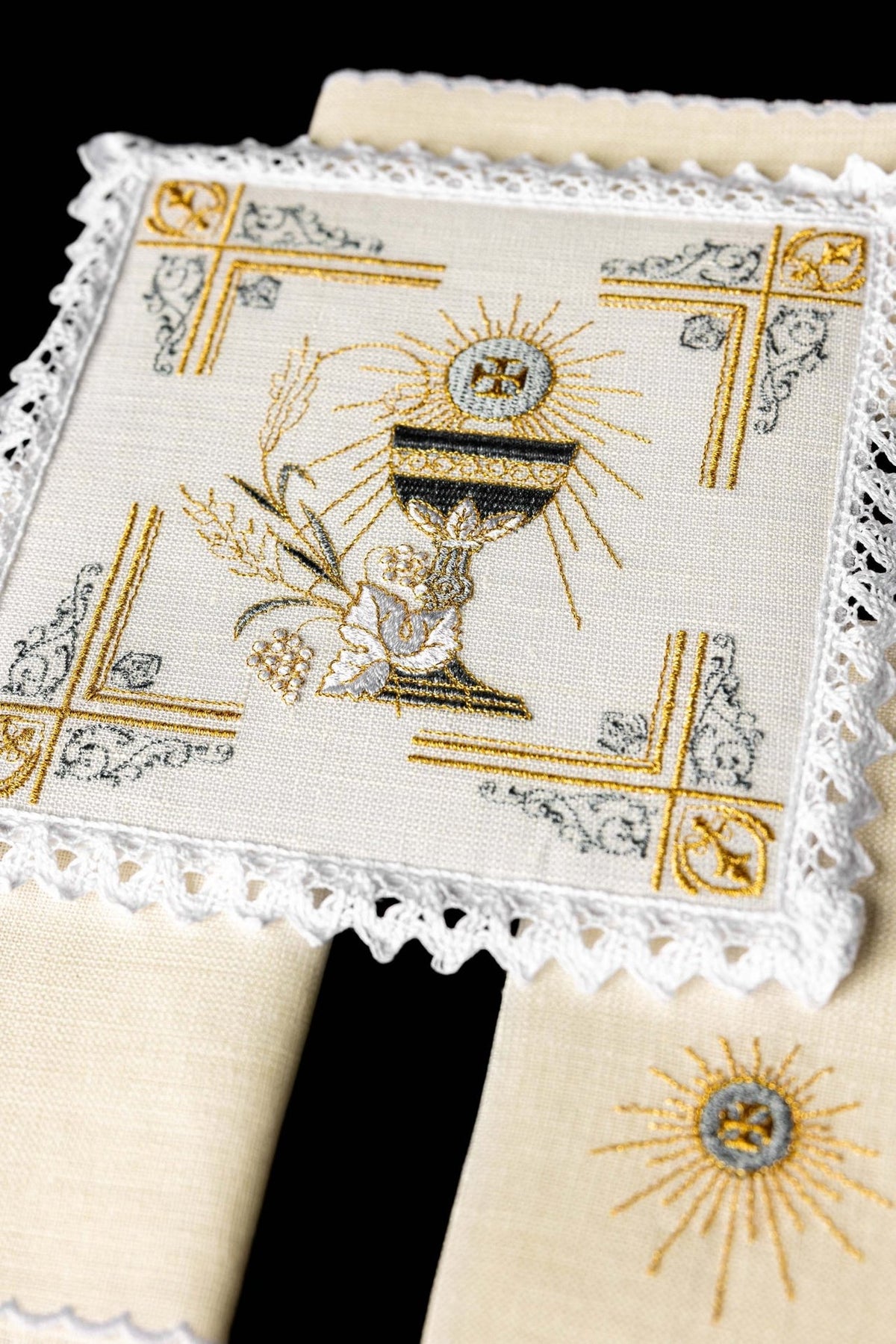 Altar linen set close-up showing embroidered chalice, Eucharistic symbol and lace trim