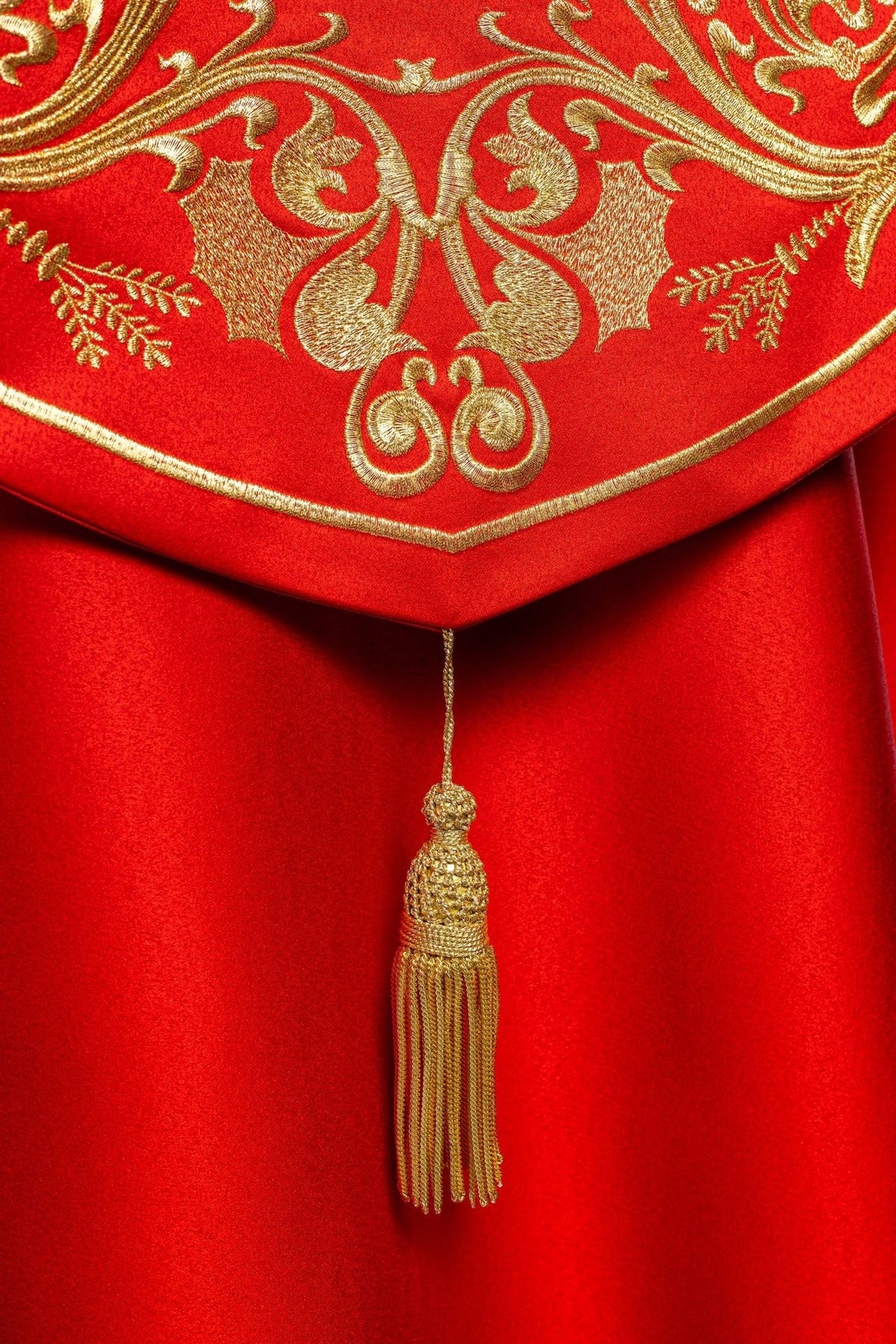 Red cope, close-up of gold embroidered floral motifs and trimmed edge