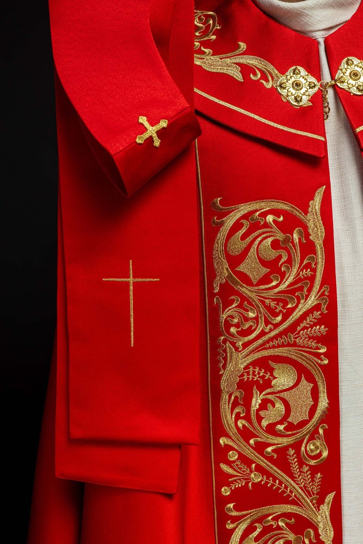Red cope, close-up of gold tassel hanging from the back