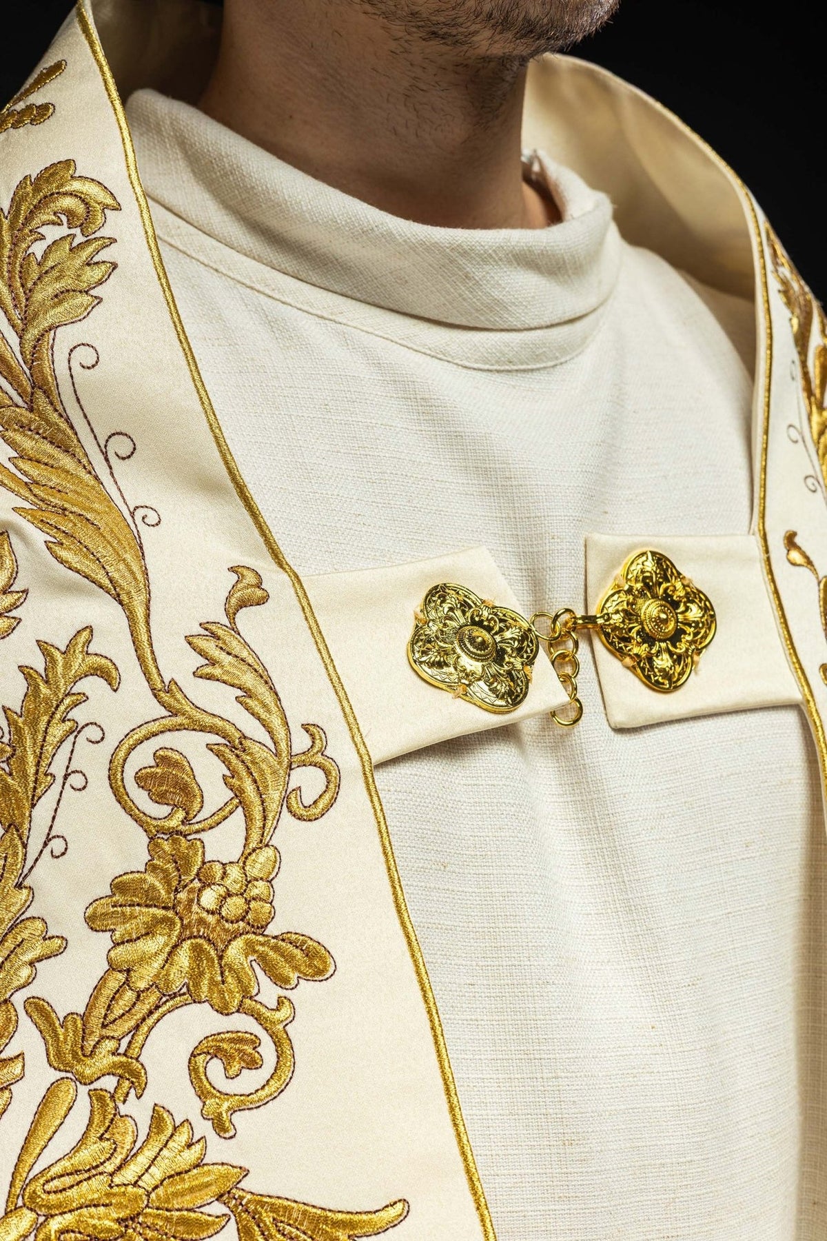 Ecru satin cope, close-up of gold floral embroidery and ornate clasp