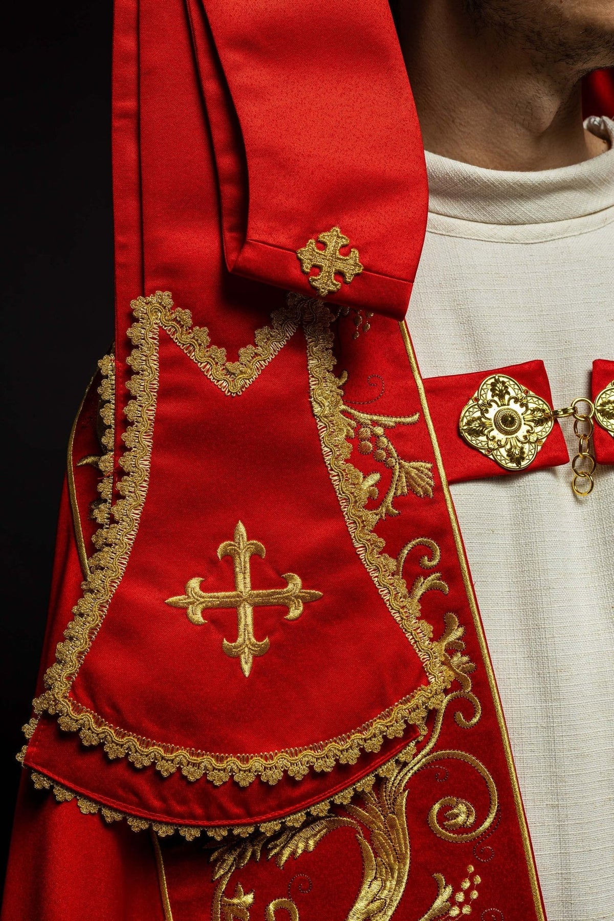 Red satin cope, close-up of gold cross embroidery and decorative trim