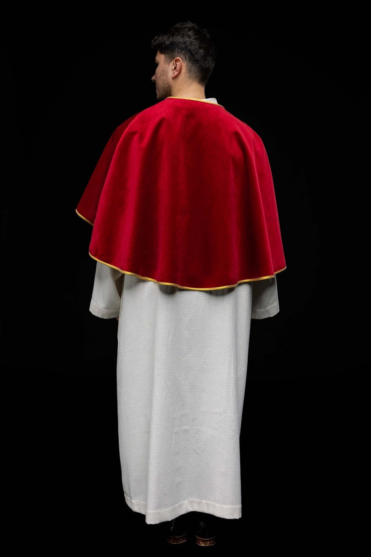 Red velvet cape back close-up with gold trim along the neckline