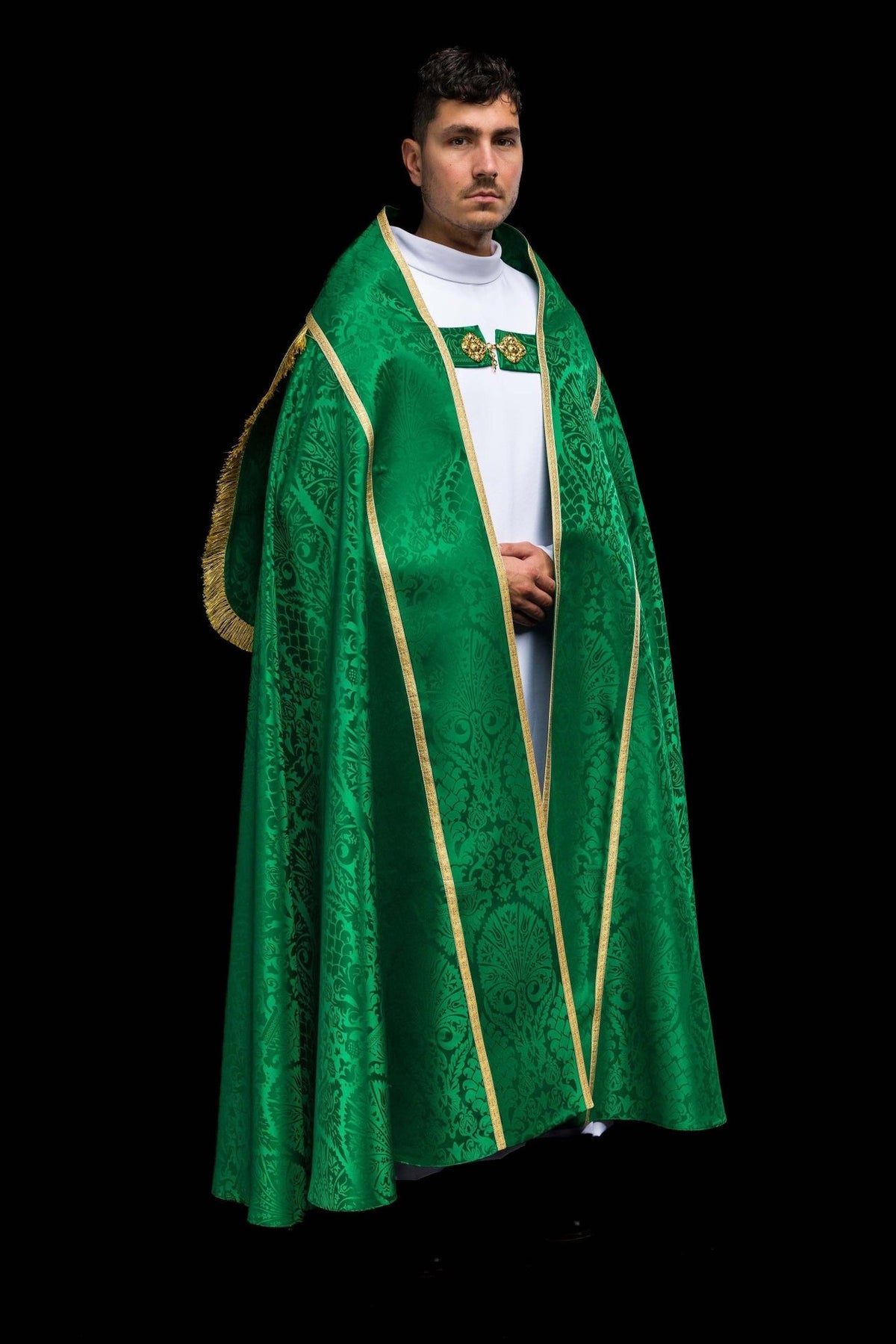 Green jacquard cope worn from the front at an angle, showing gold trim and ornate woven motifs