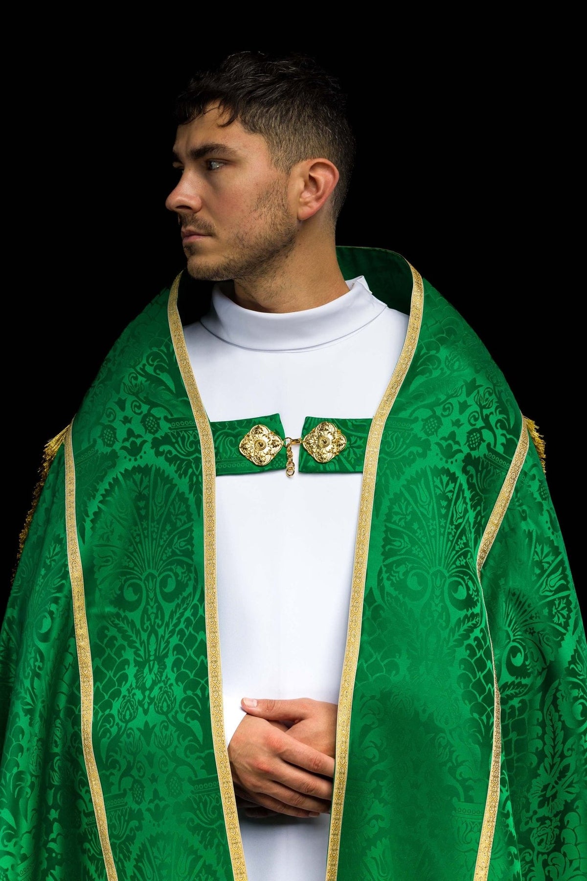 Green jacquard cope worn in a close front view with gold edging and ornate fabric motifs