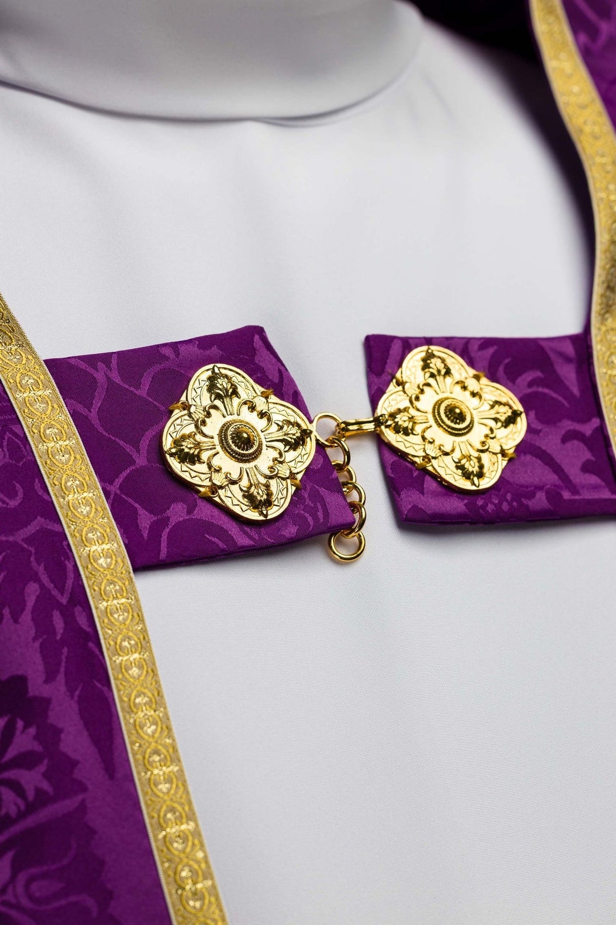 Roman cope front detail showing ornate gold clasp and purple jacquard fabric