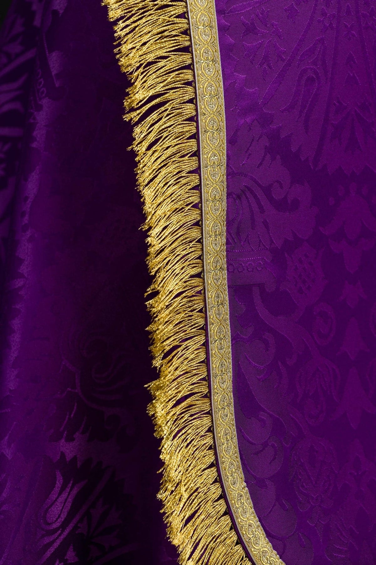 Purple cope close-up showing gold fringe and jacquard fabric