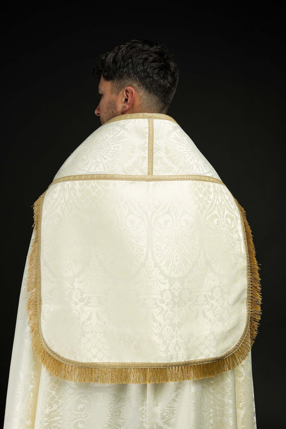 Ecru Roman cope back view with patterned panel, gold trim and fringe