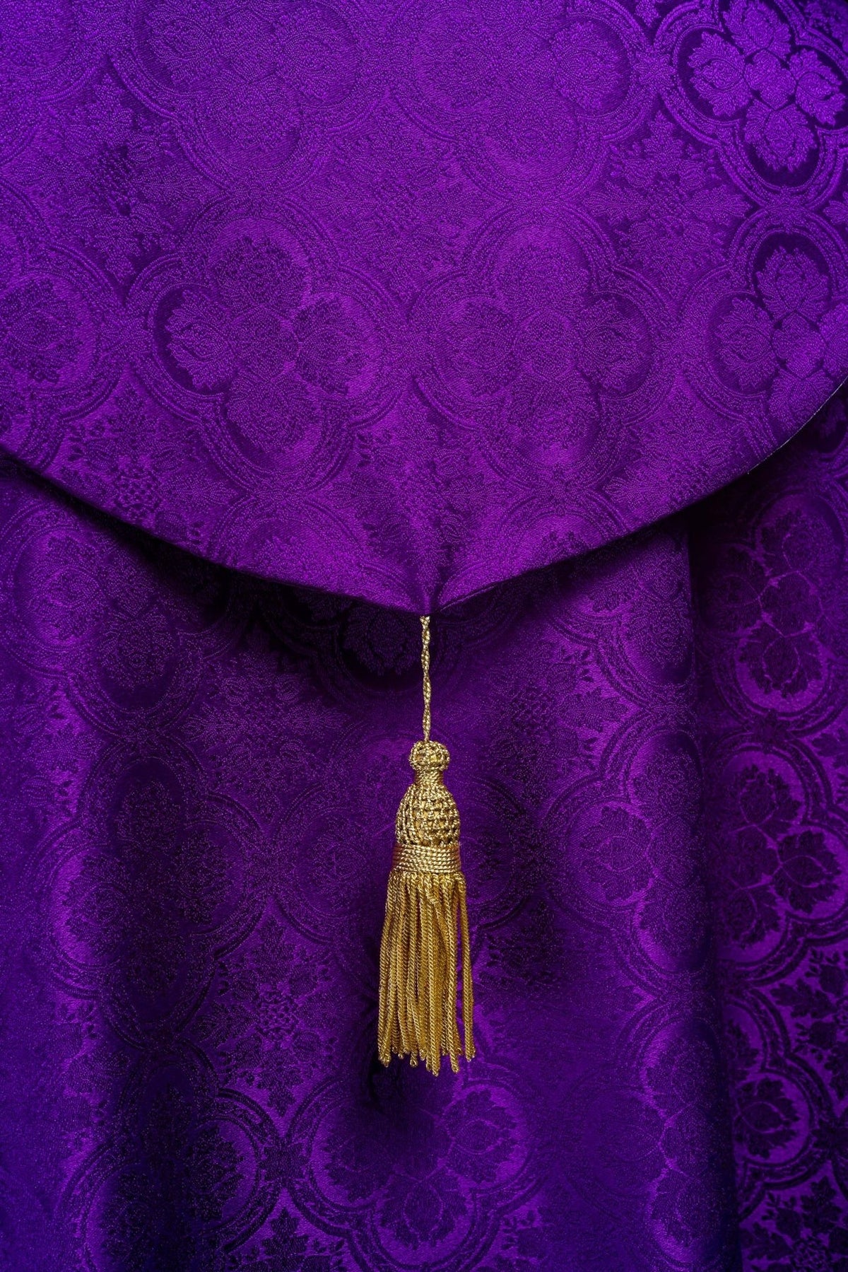 Purple cope close-up showing the gold tassel on the back