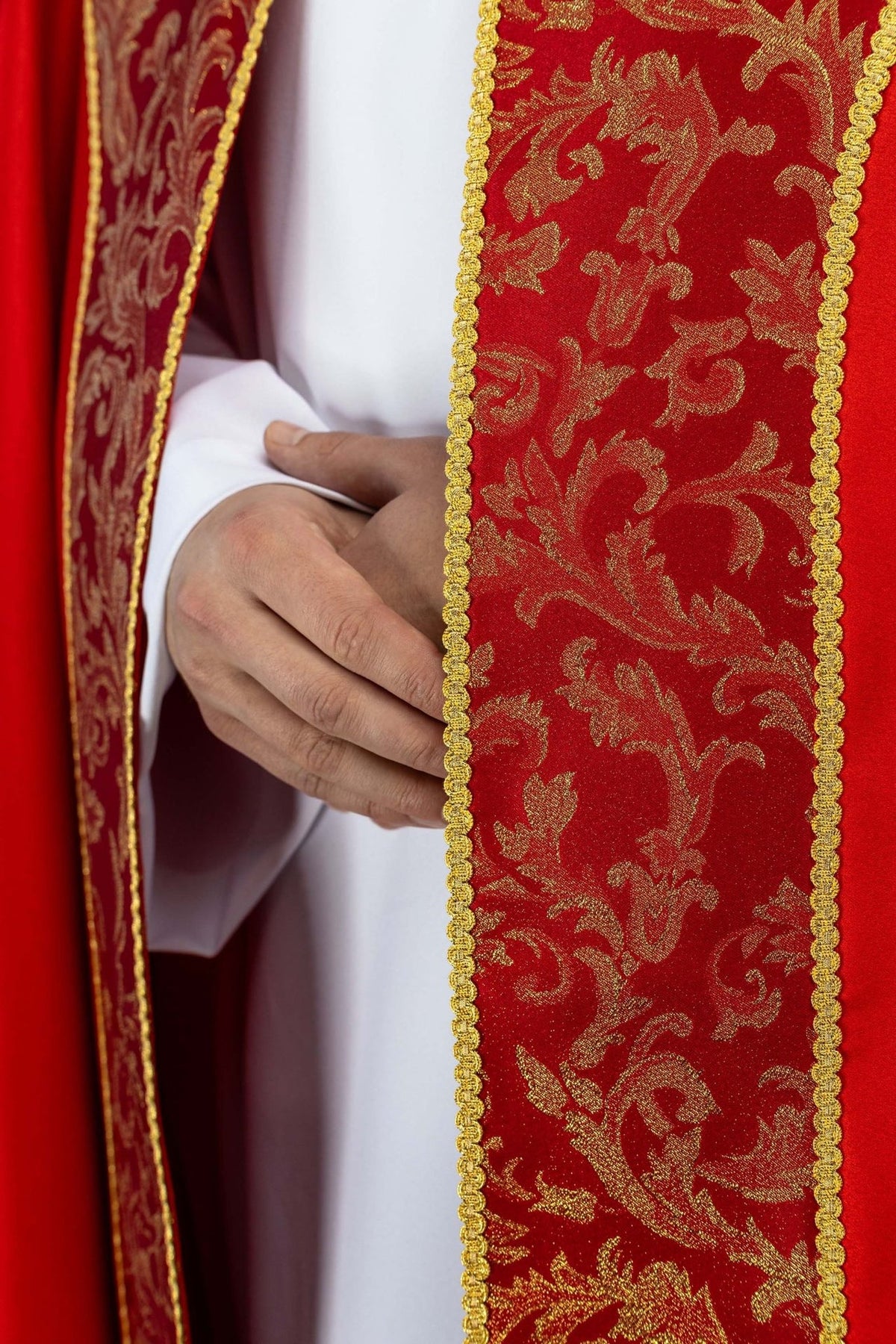 Red cope, close-up of gold floral jacquard fabric and trim