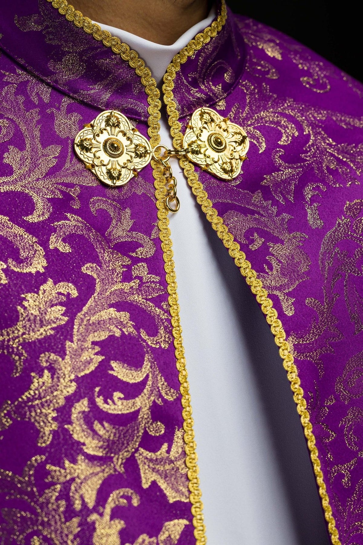 Purple cope close-up of gold clasp, trim and jacquard fabric floral motifs