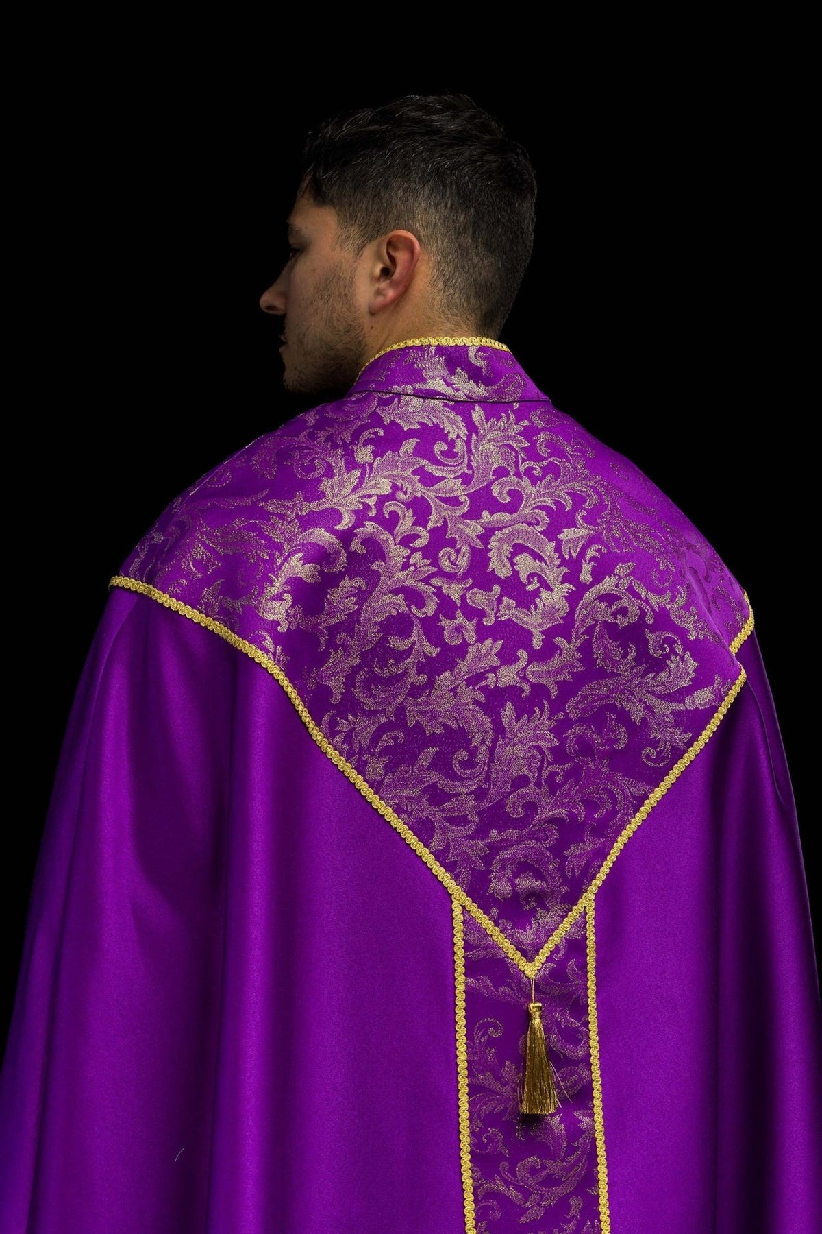 Purple cope close-up showing gold floral jacquard fabric and trim