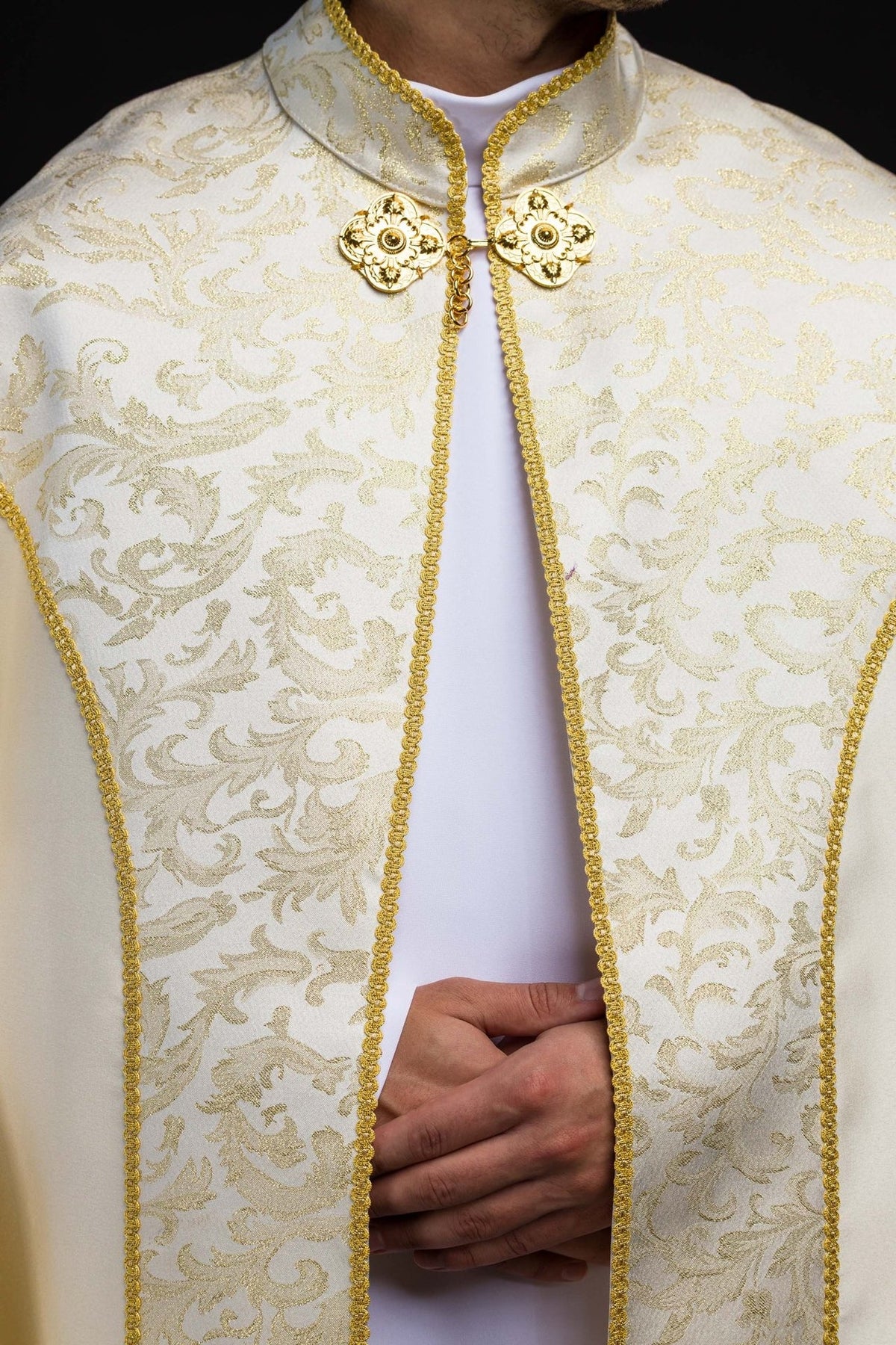 Ecru cope front detail with gold floral clasp and patterned jacquard fabric