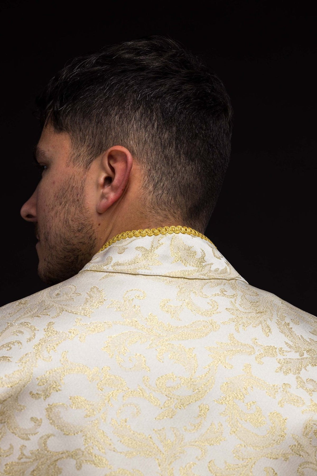 Ecru cope back close-up with jacquard fabric decoration and gold collar trim