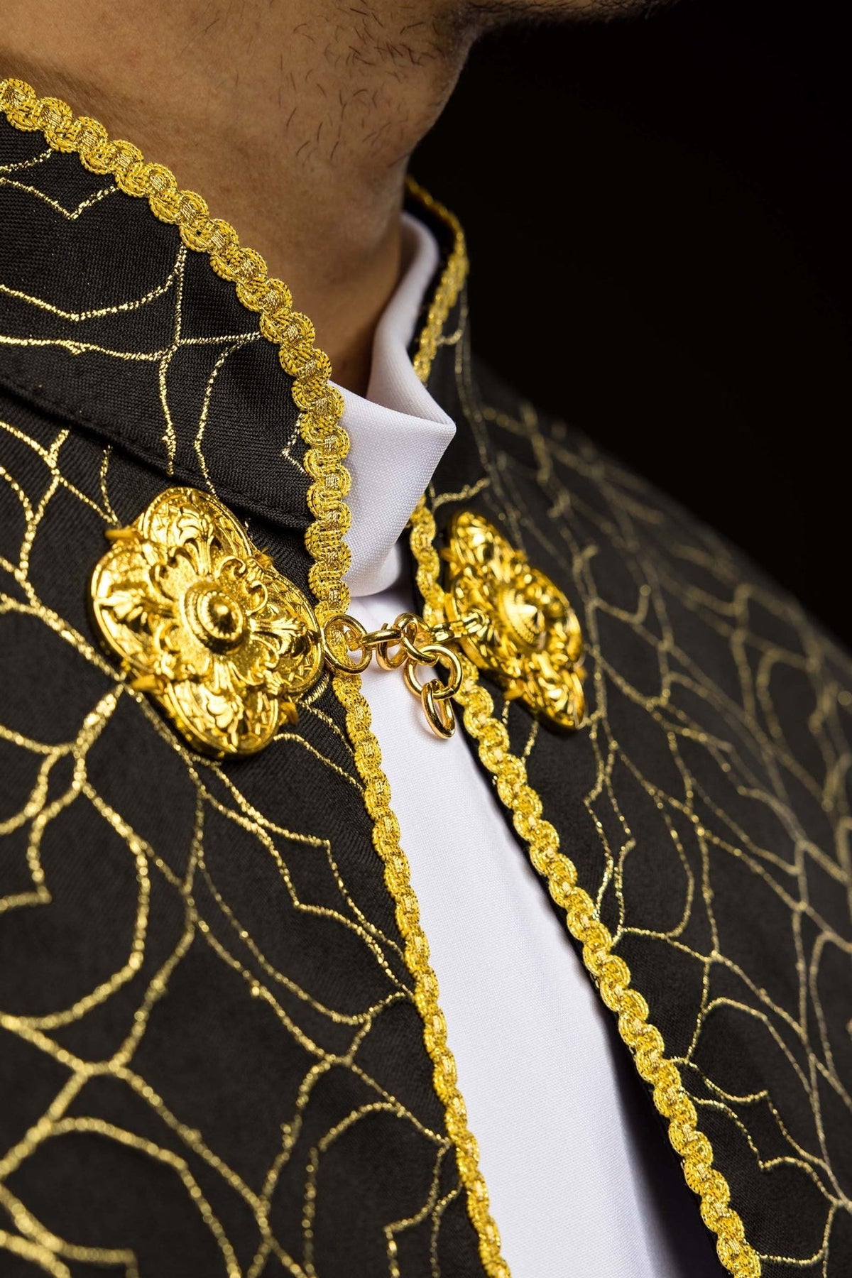 Black cope upper front close-up showing gold trim, clasp and jacquard fabric