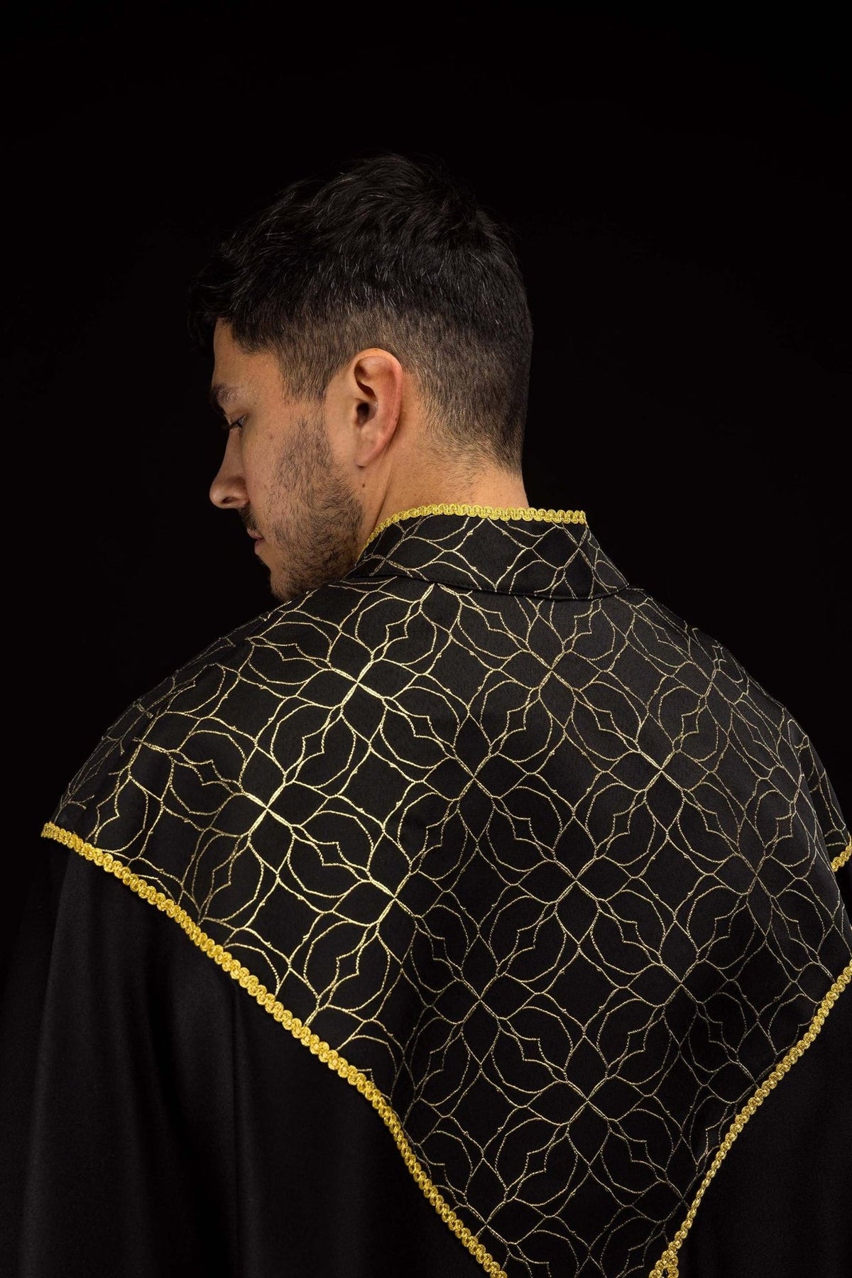 Black cope back close-up with gold floral pattern and trim