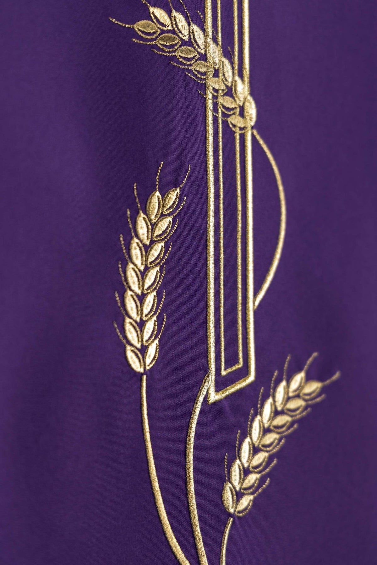 Purple lectern cover close-up showing gold wheat embroidery beside the cross