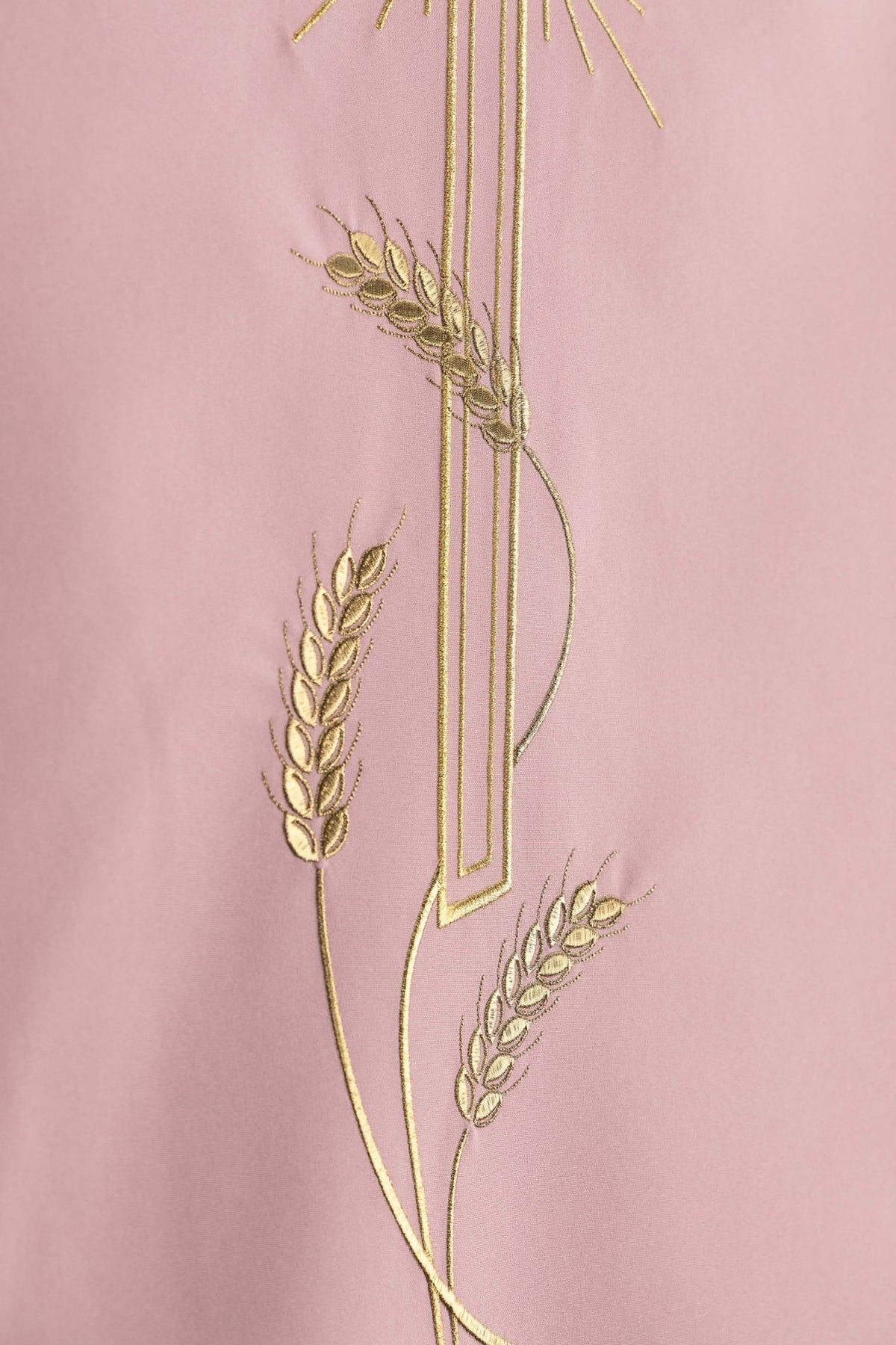 Church lectern cover close-up showing gold wheat embroidery around the cross