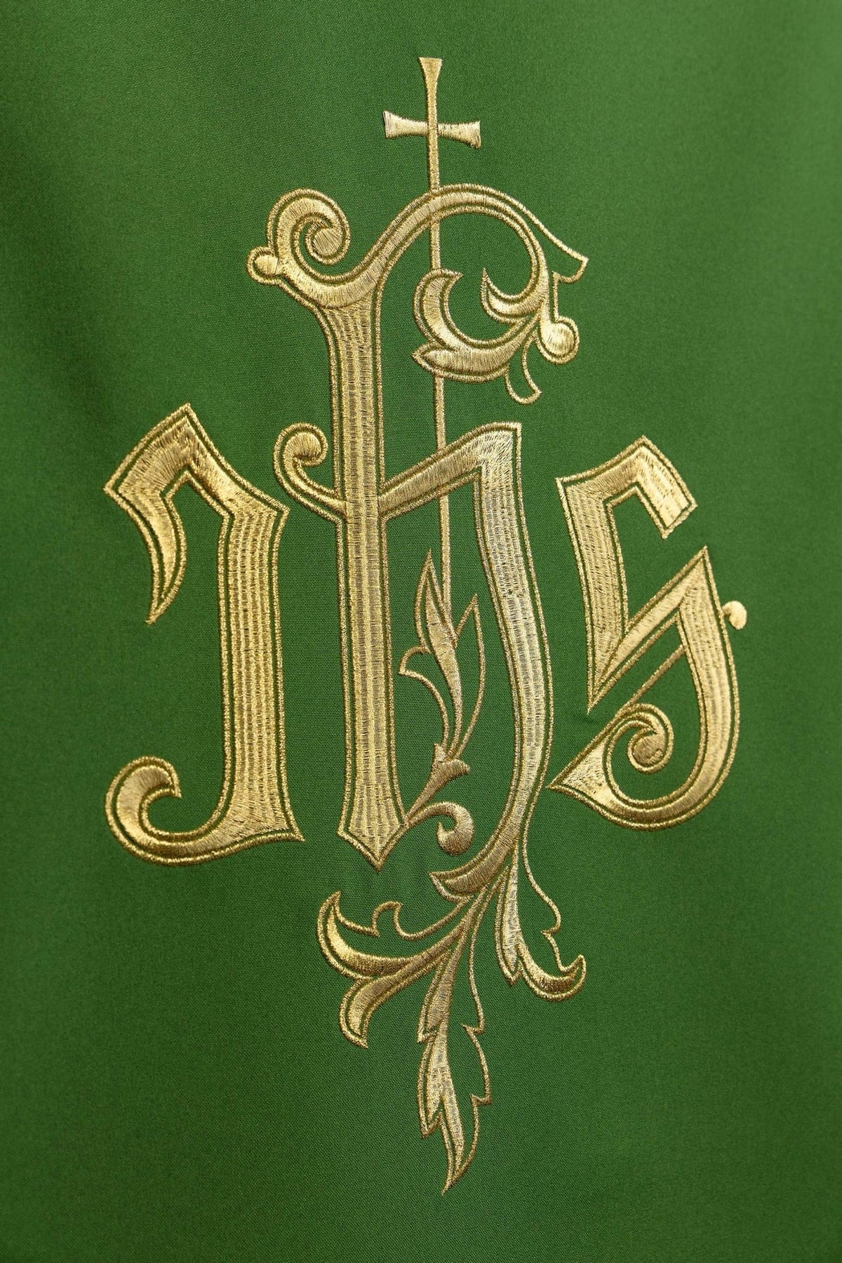 Green church lectern cover close-up showing gold embroidered IHS and cross