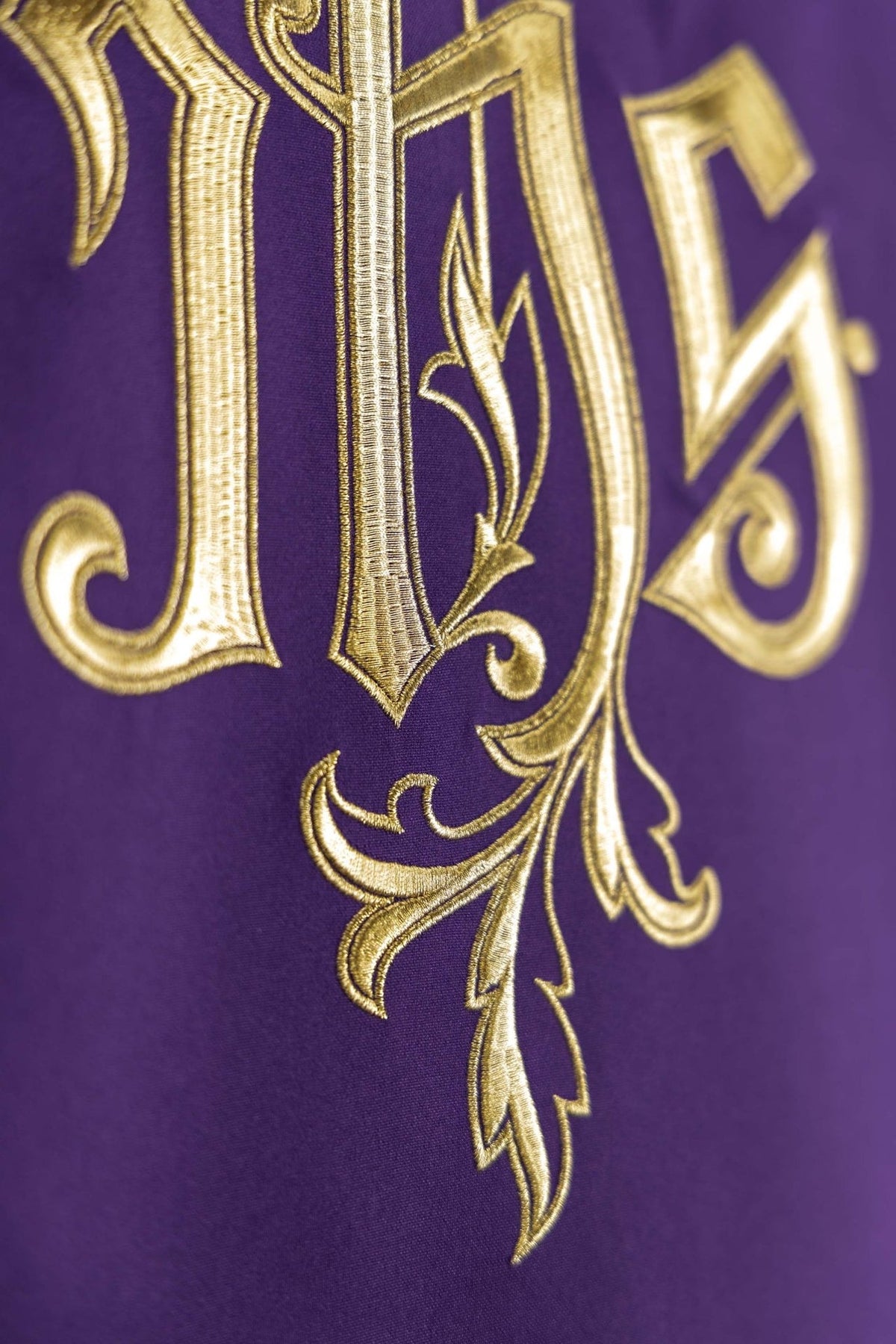 Church lectern cover close-up showing gold IHS embroidery and decorative leaf details