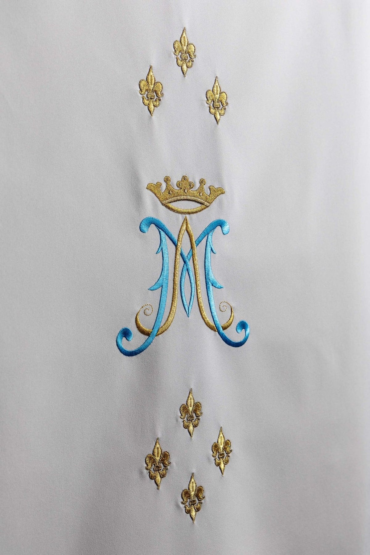 Church lectern cover close-up showing Marian motif with blue and gold embroidery
