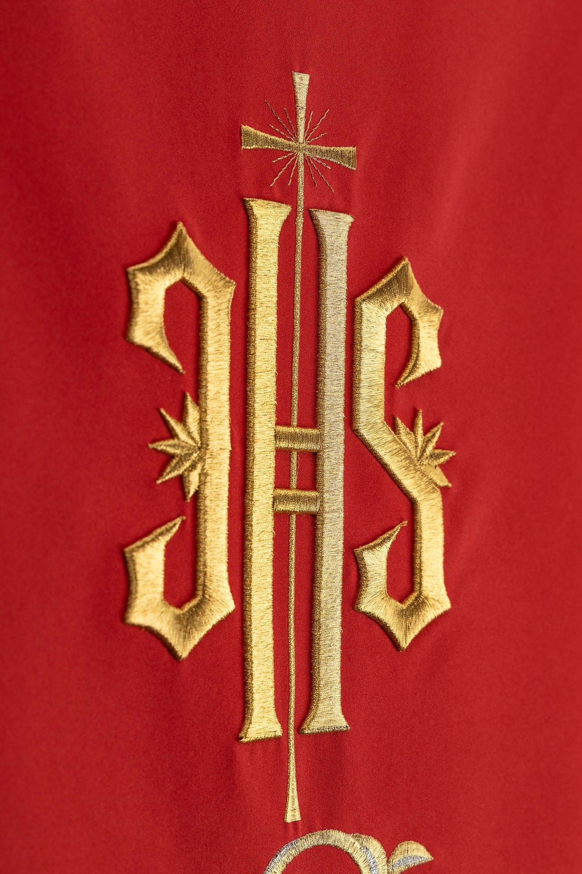 Church lectern cover close-up showing the gold IHS monogram and cross embroidery