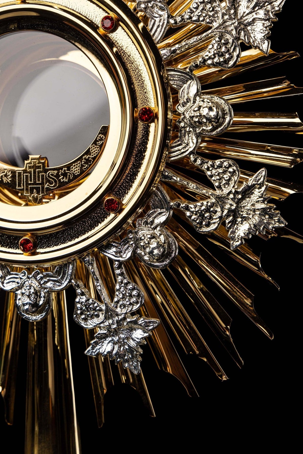 Monstrance close-up of silver-tone grapes, leaves and red-studded host ring