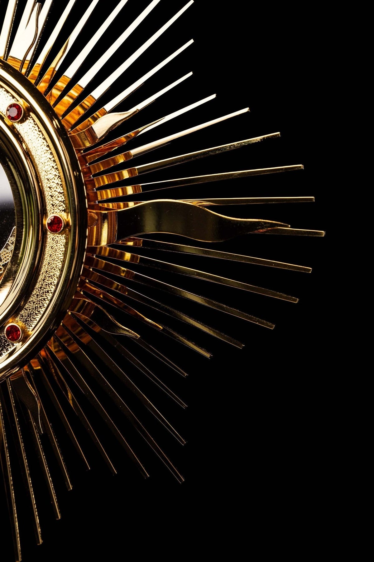 Gold-plated radiant monstrance side detail with layered rays and decorative flame shape