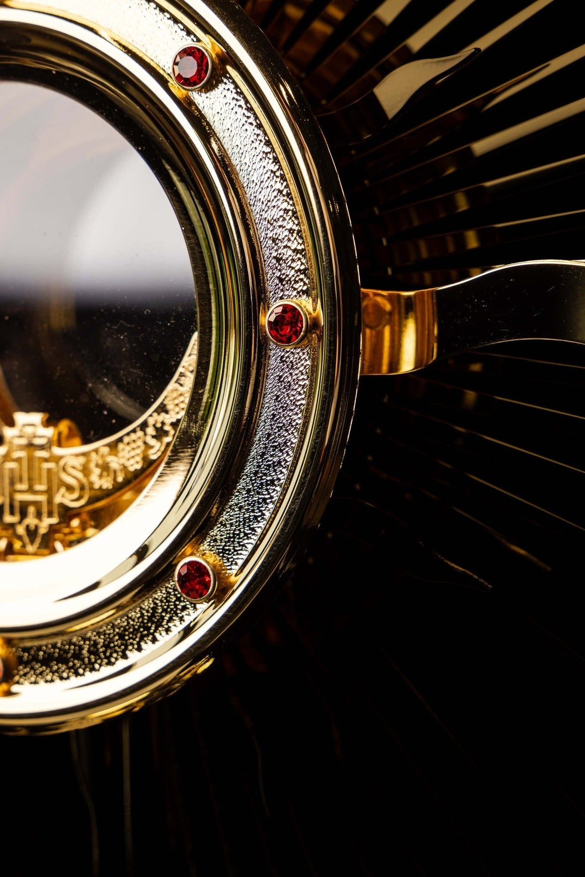 Gold-plated radiant monstrance front detail with cross, rays and red stones
