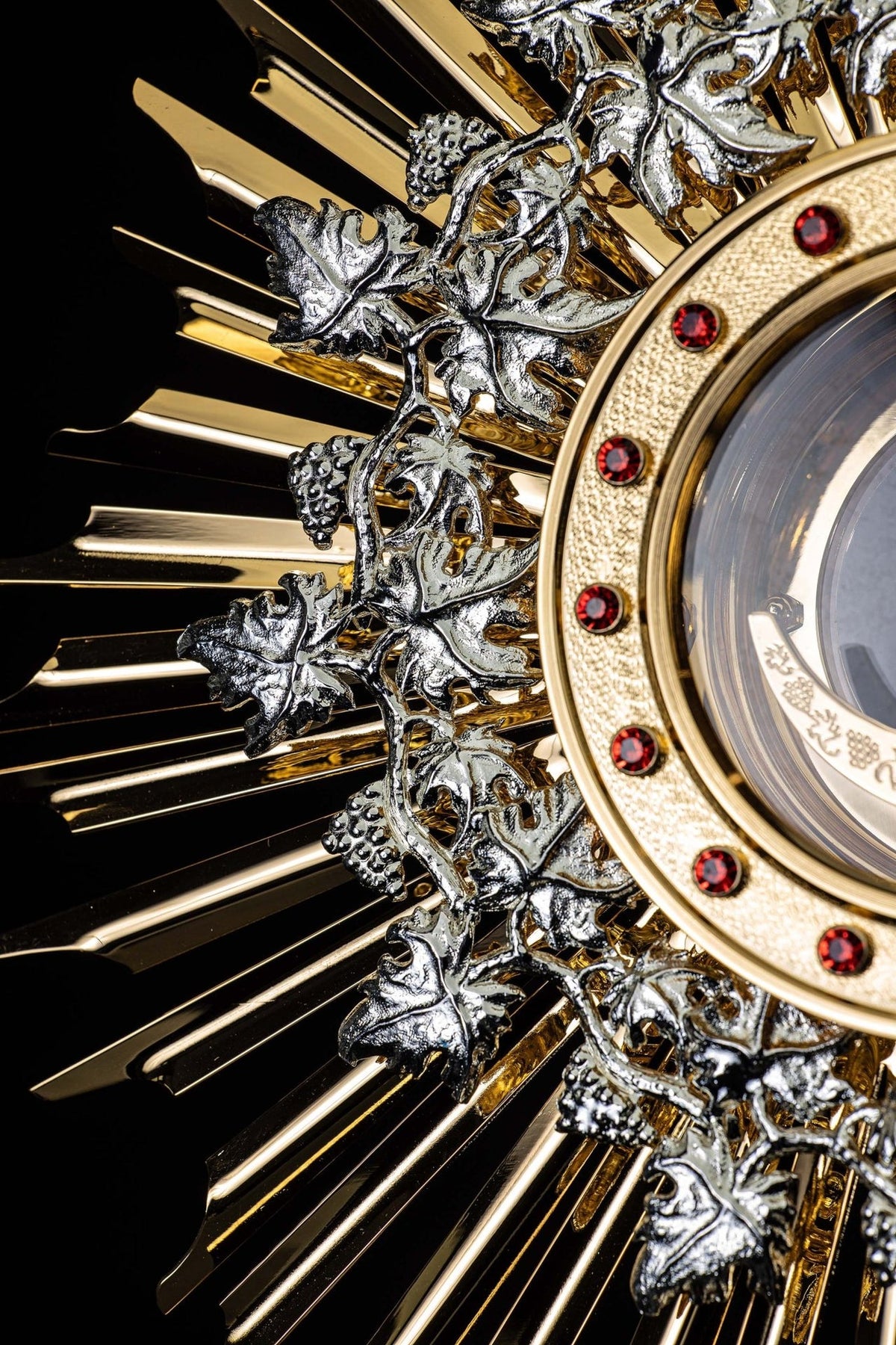 Monstrance detail showing silver grapevine motifs over gold sunburst rays