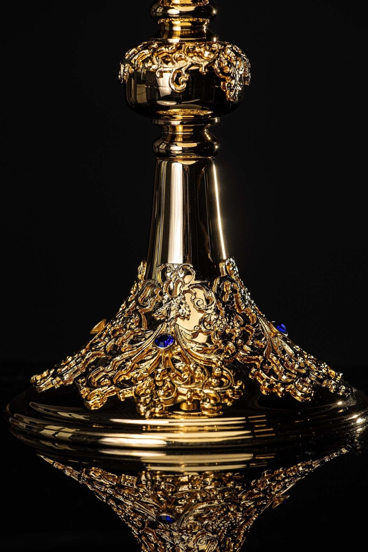 Gold-plated chalice close-up of ornate rounded knop with scrolling botanical details