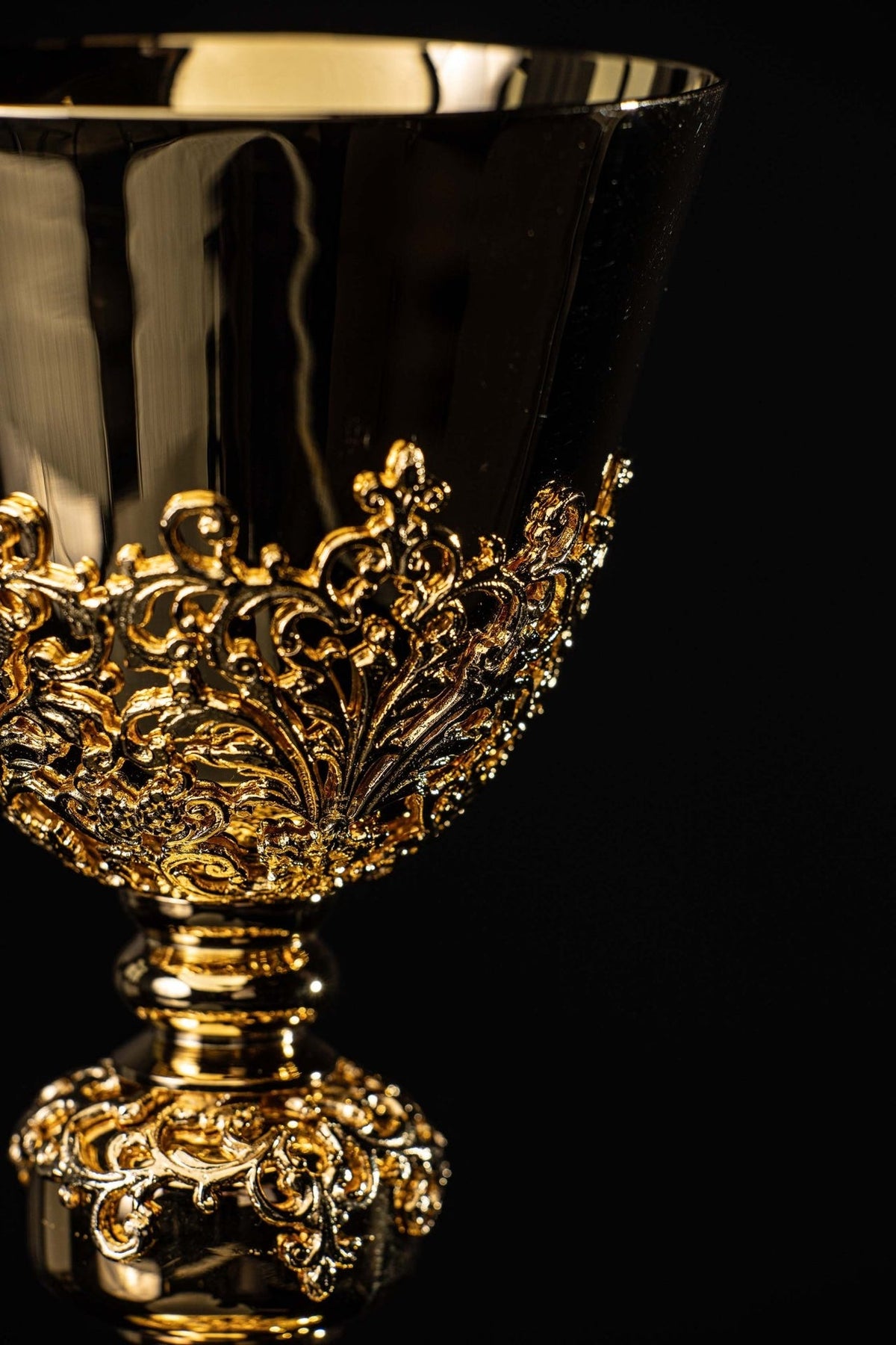 Gold-plated chalice cup close-up with raised botanical ornament band