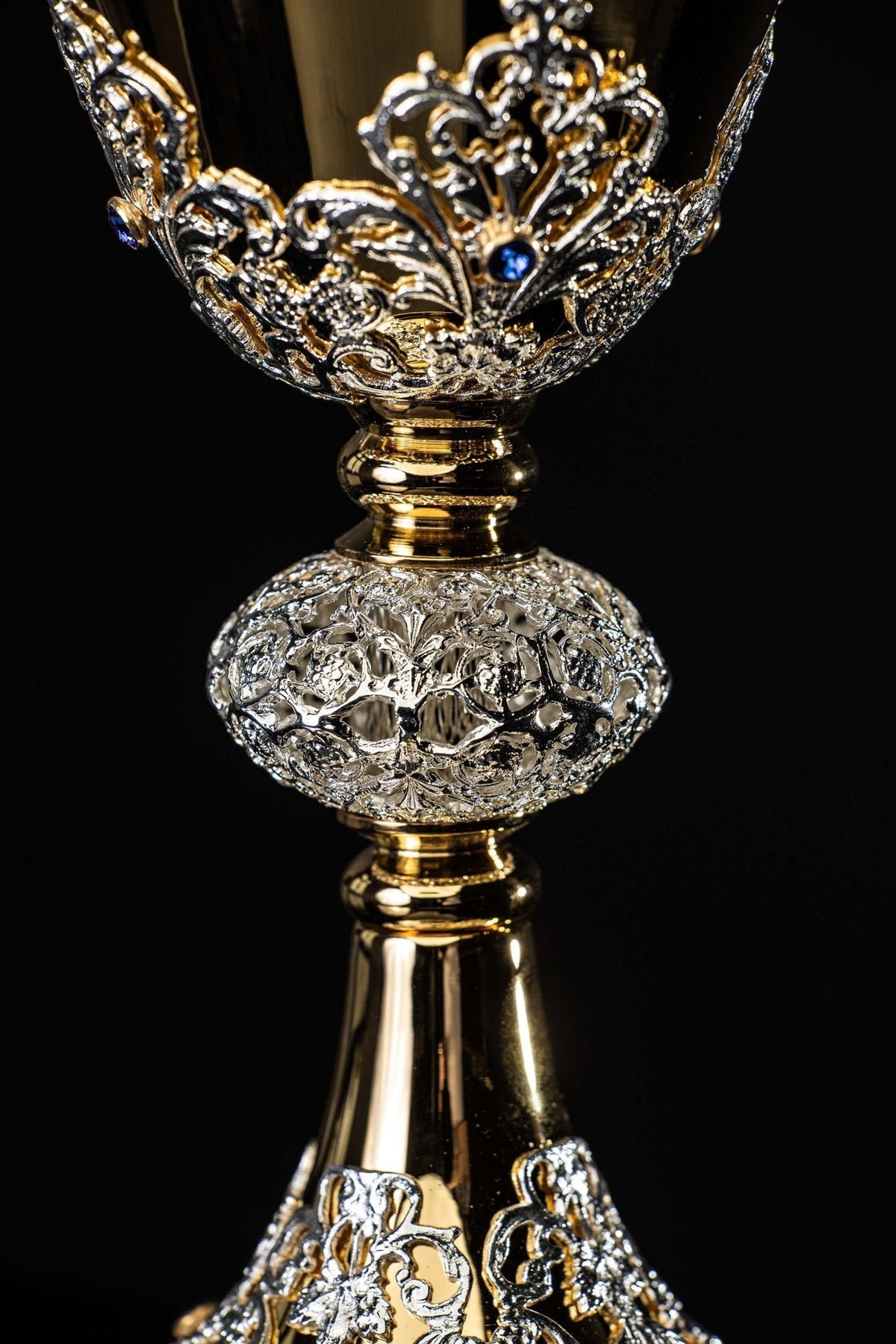 Chalice close-up showing raised floral scrollwork and imitation sapphire on the bowl