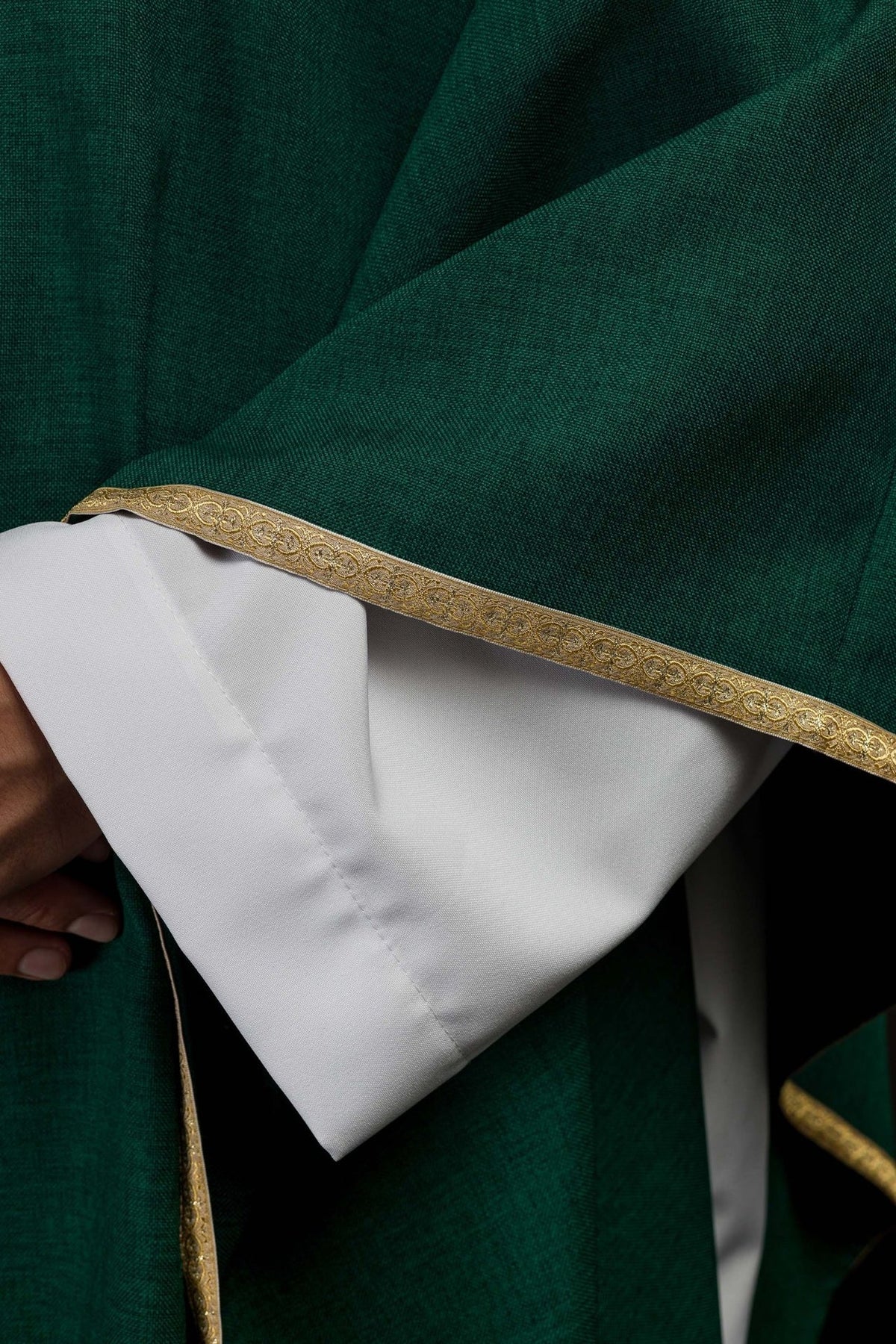 Green chasuble detail showing gold trim on the sleeve edge