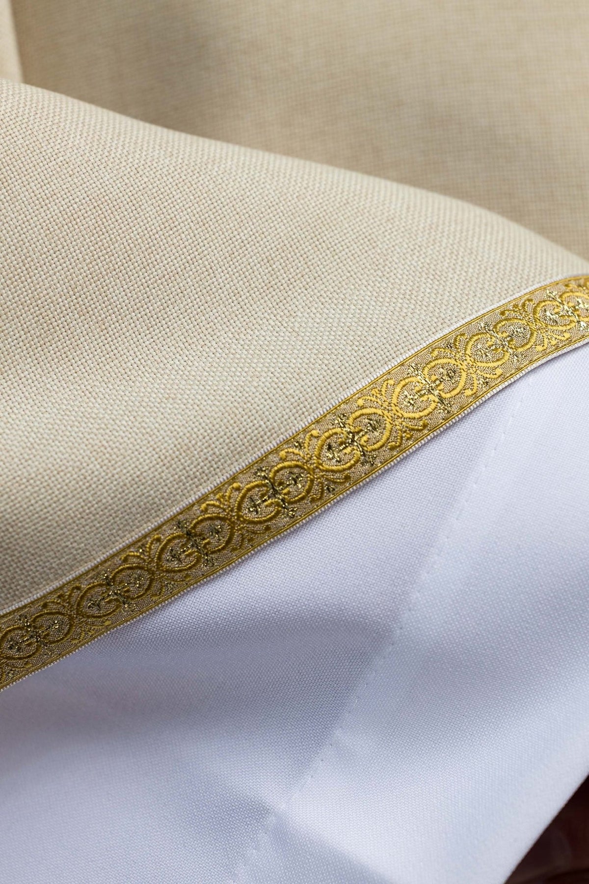 Ecru chasuble close-up of gold trim and woven fabric
