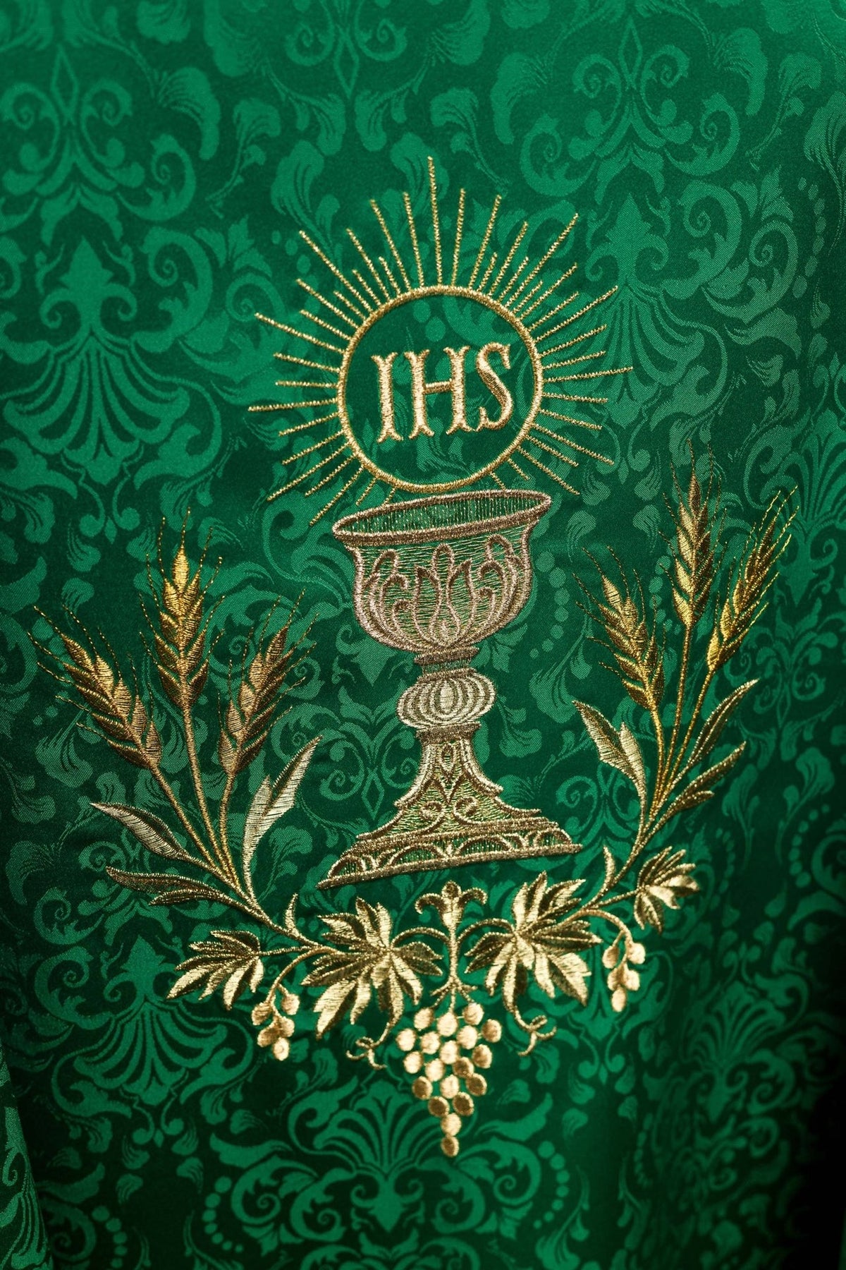 Green chasuble close-up showing chalice, IHS monogram, wheat and floral embroidery