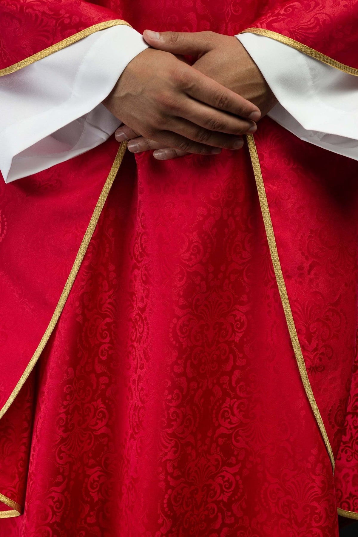 Red chasuble detail showing gold trim along the front edges