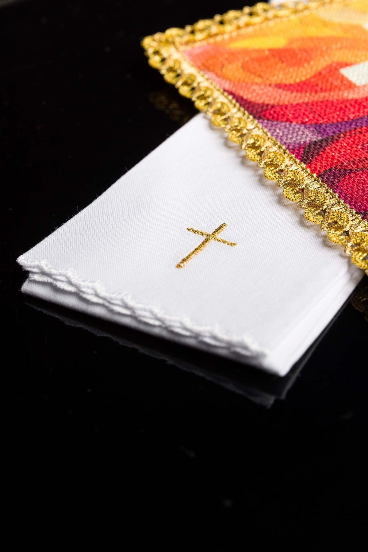 Altar linen set detail showing folded white linen with gold cross and scalloped edges