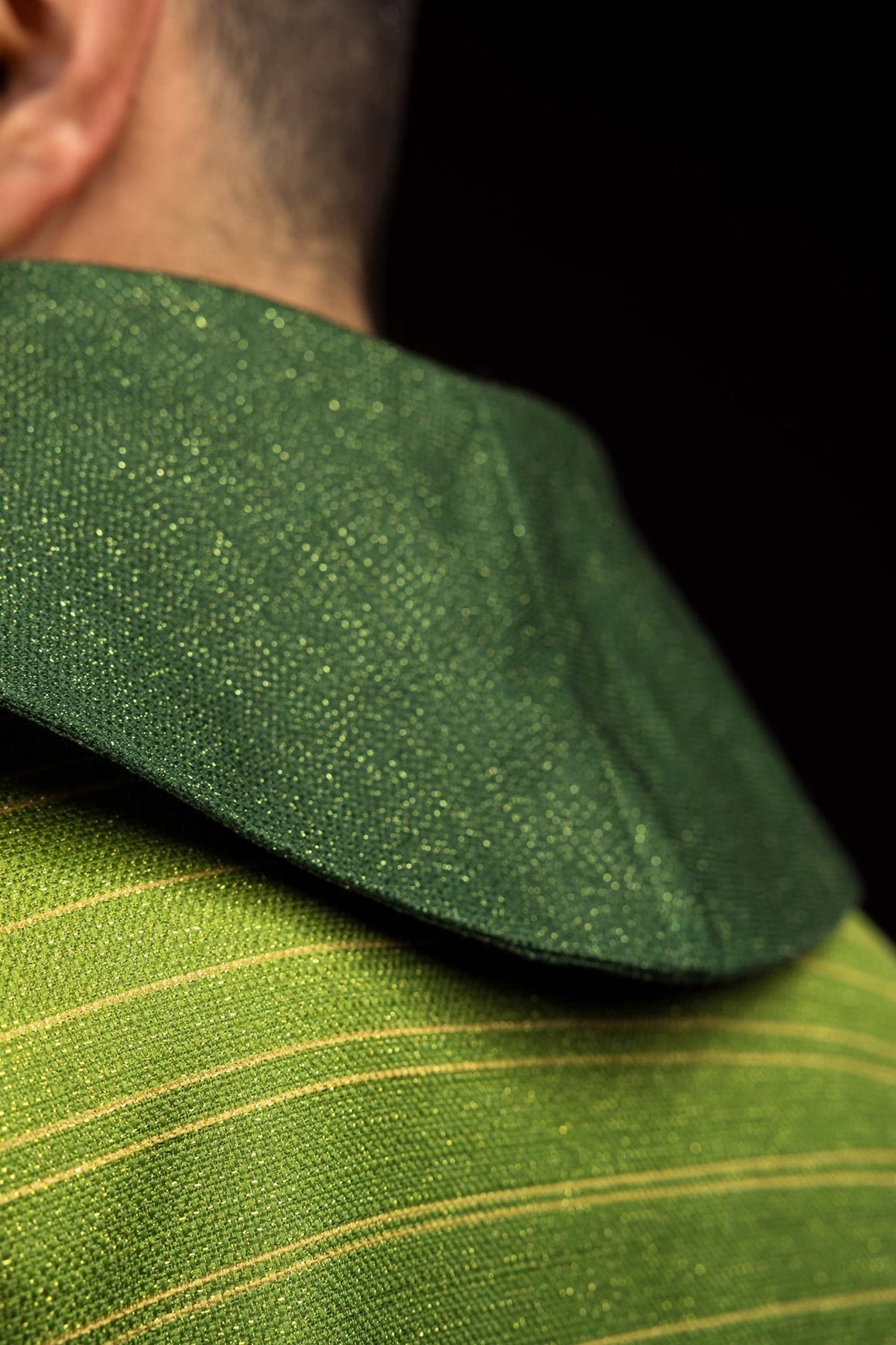 Green chasuble close-up showing textured collar and horizontal gold trim