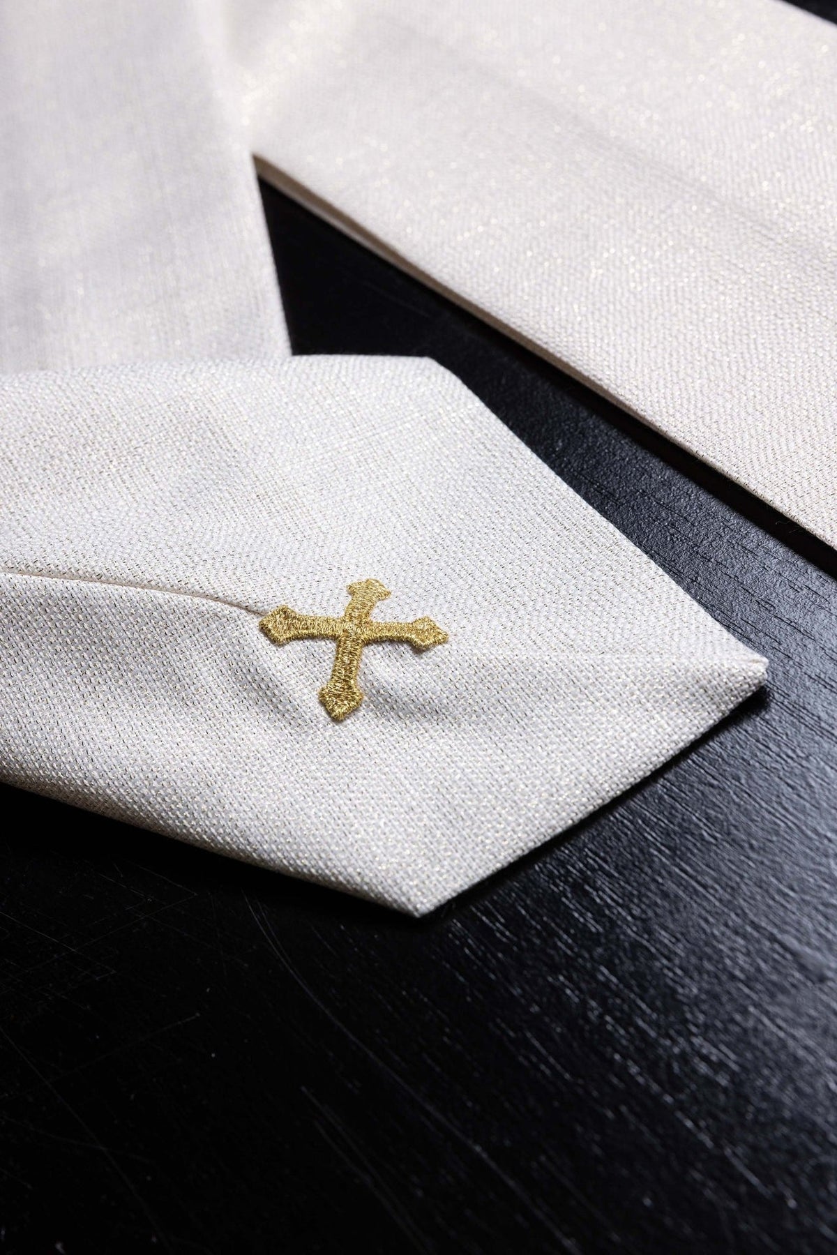 Ecru Catholic chasuble close-up showing gold cross embroidery and gold trim